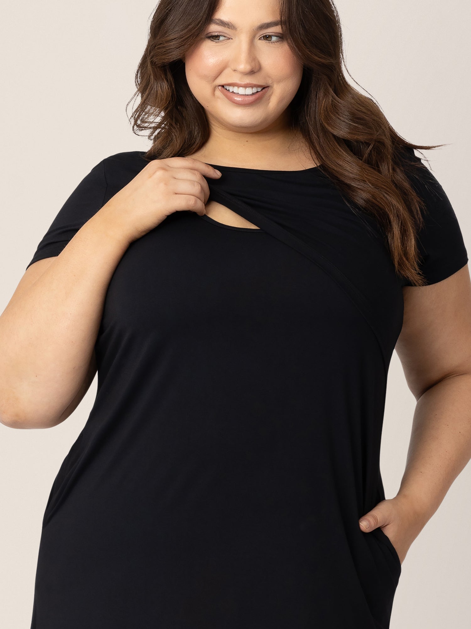 Model pulling up the convenient pull up nursing panel on the Eleanora Bamboo Maternity & Nursing Dress in Black.