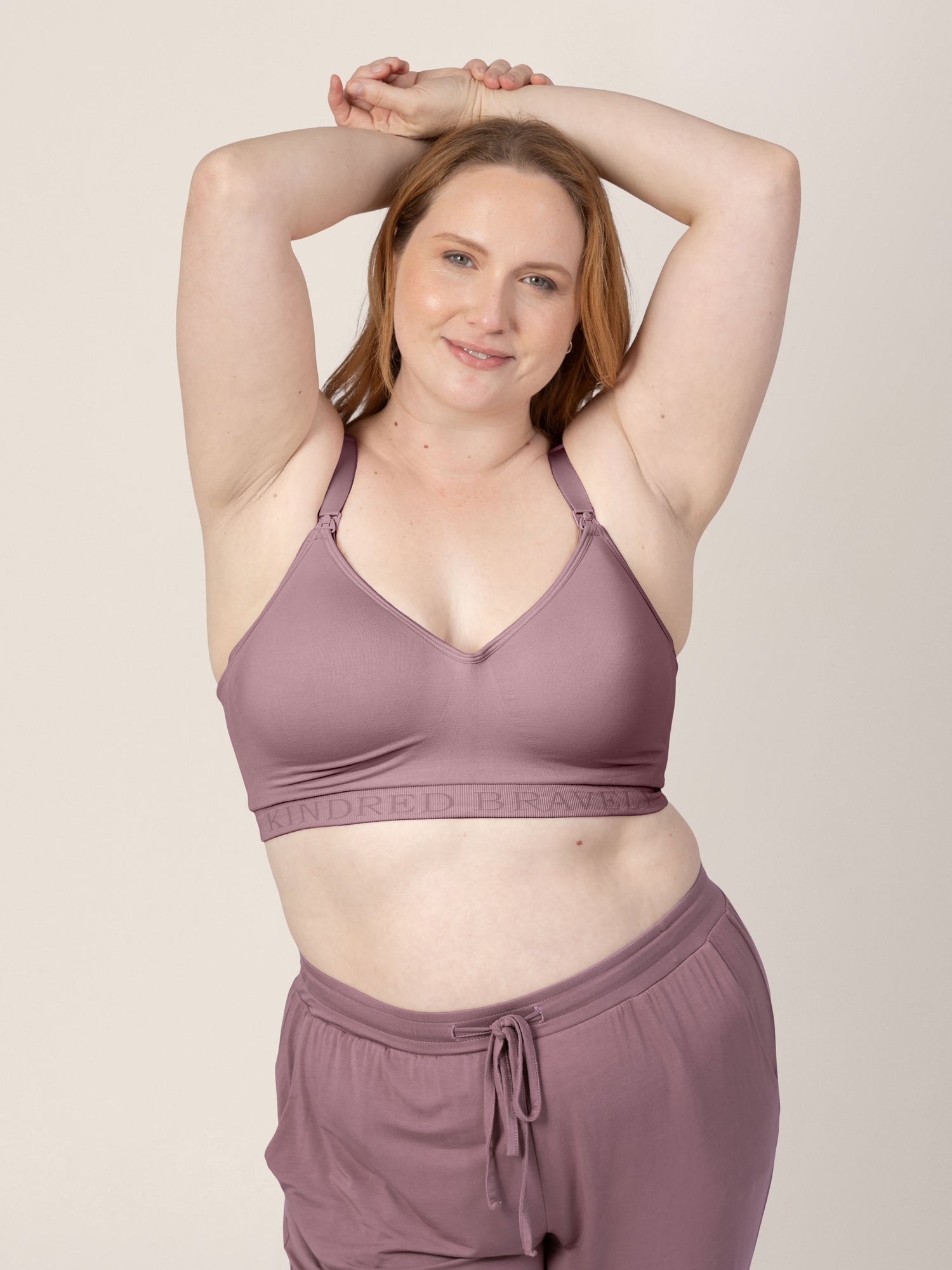 Busty model holding her hands over her head while wearing the Signature Sublime® Contour Maternity & Nursing Bra in Twilight@model_info:Ryn is wearing an X-Large Busty.