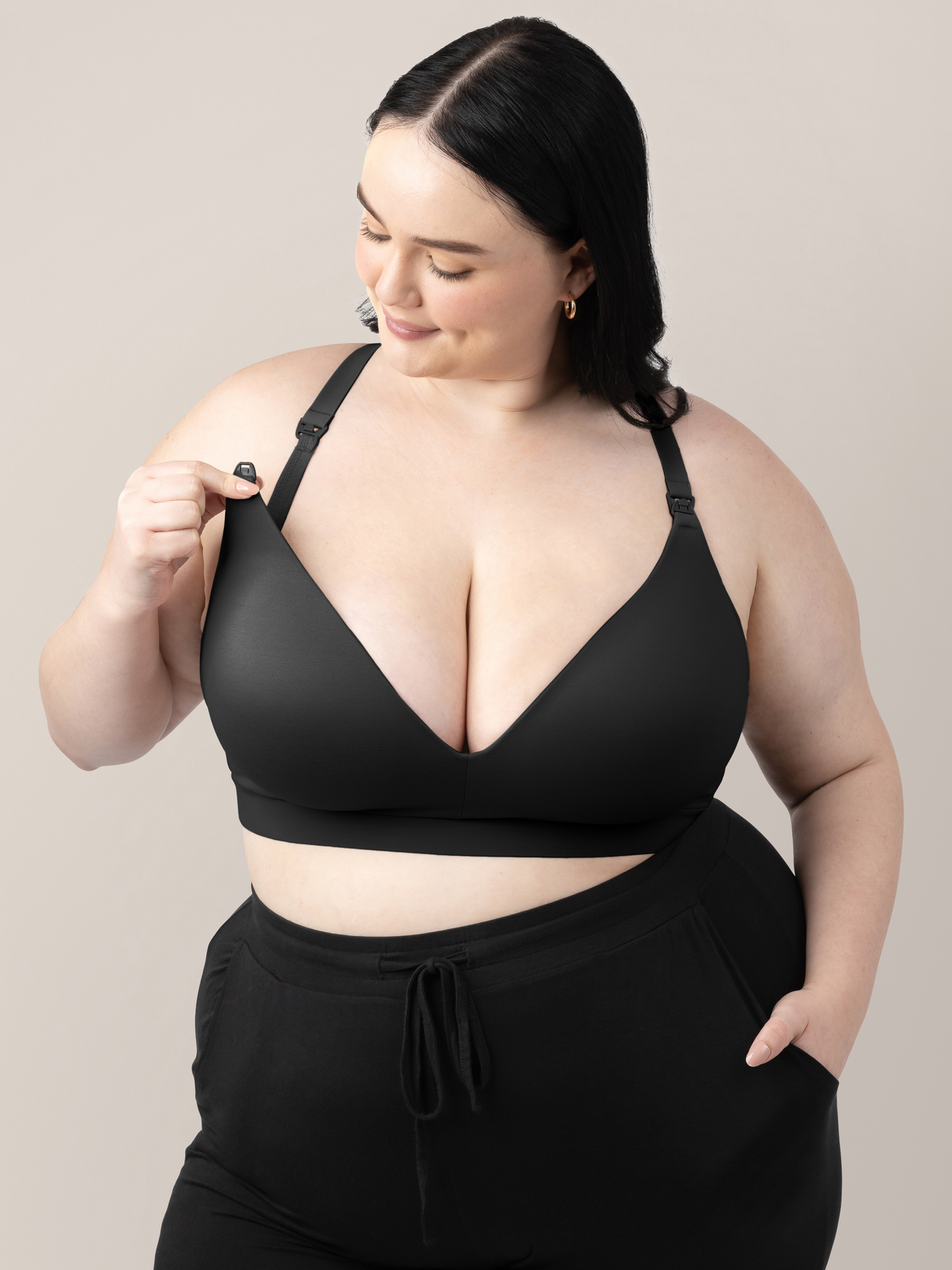 Model wearing the Minimalist Maternity & Nursing Bra in Black showing the easy clip down nursing access. @model_info:Kenna is wearing a 1X Busty.