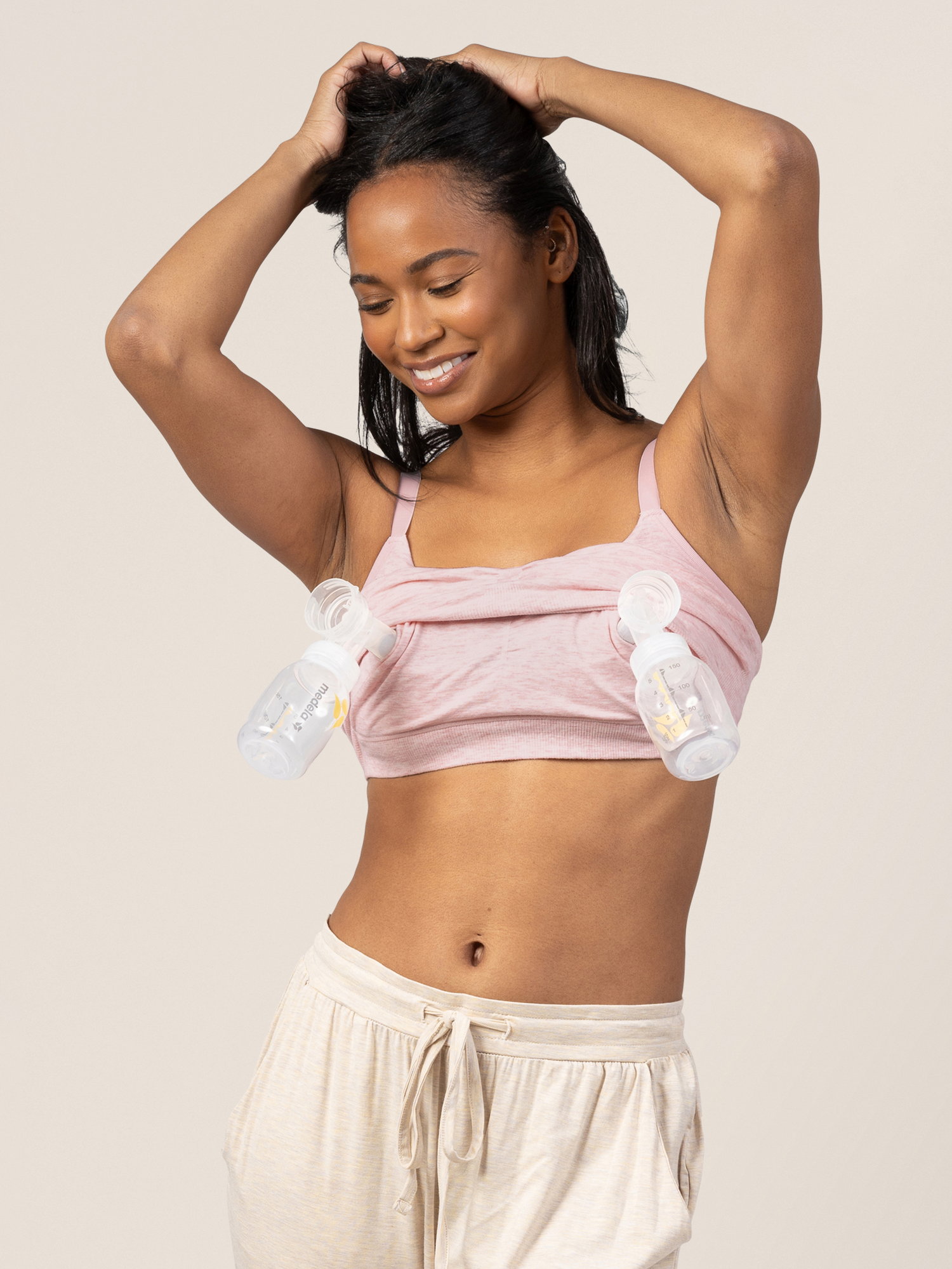 Front view of model wearing the Sublime® Bamboo Hands-Free Pumping Lounge & Sleep Bra in pink heather with two pumping flanges and bottles