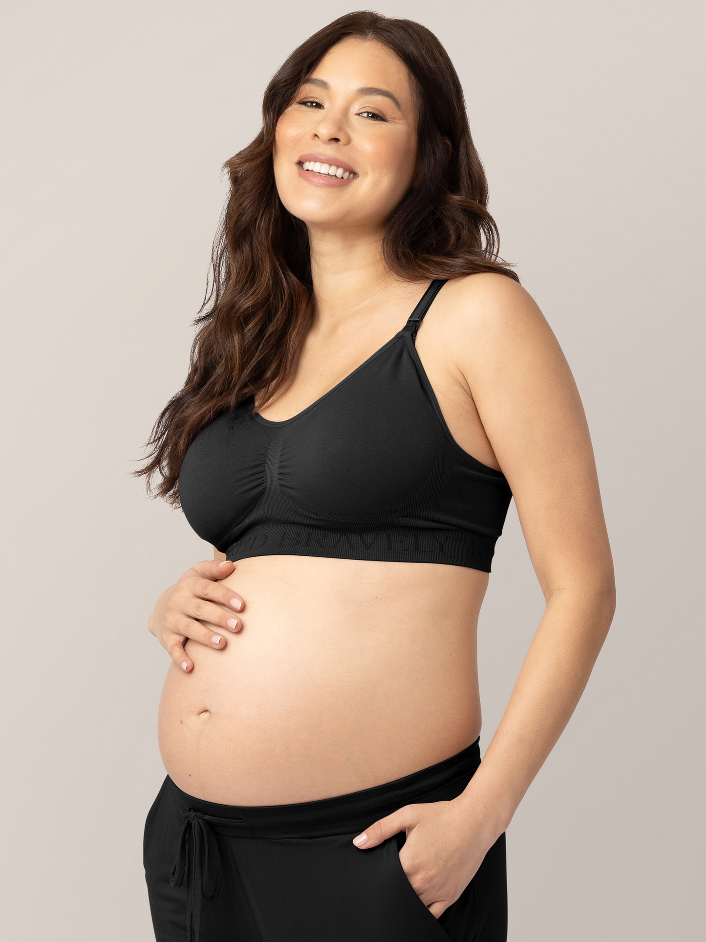 Pregnant model wearing the Simply Sublime® Nursing Bra in Black with her hand in her pocket.