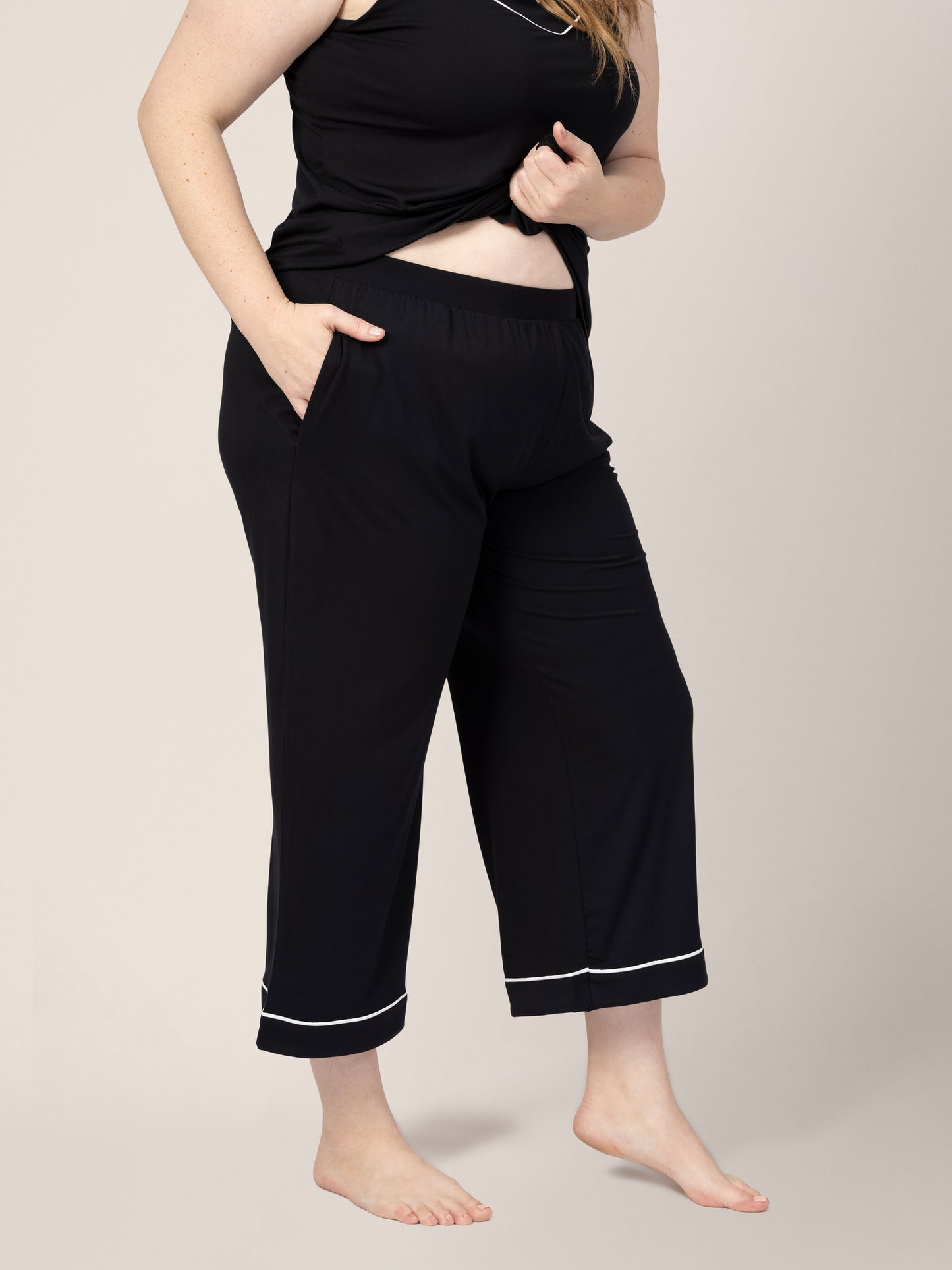 Close-up of waistband on model wearing Clea Bamboo Nursing Tank & Capri Pajama Set in Black, with hand in pocket