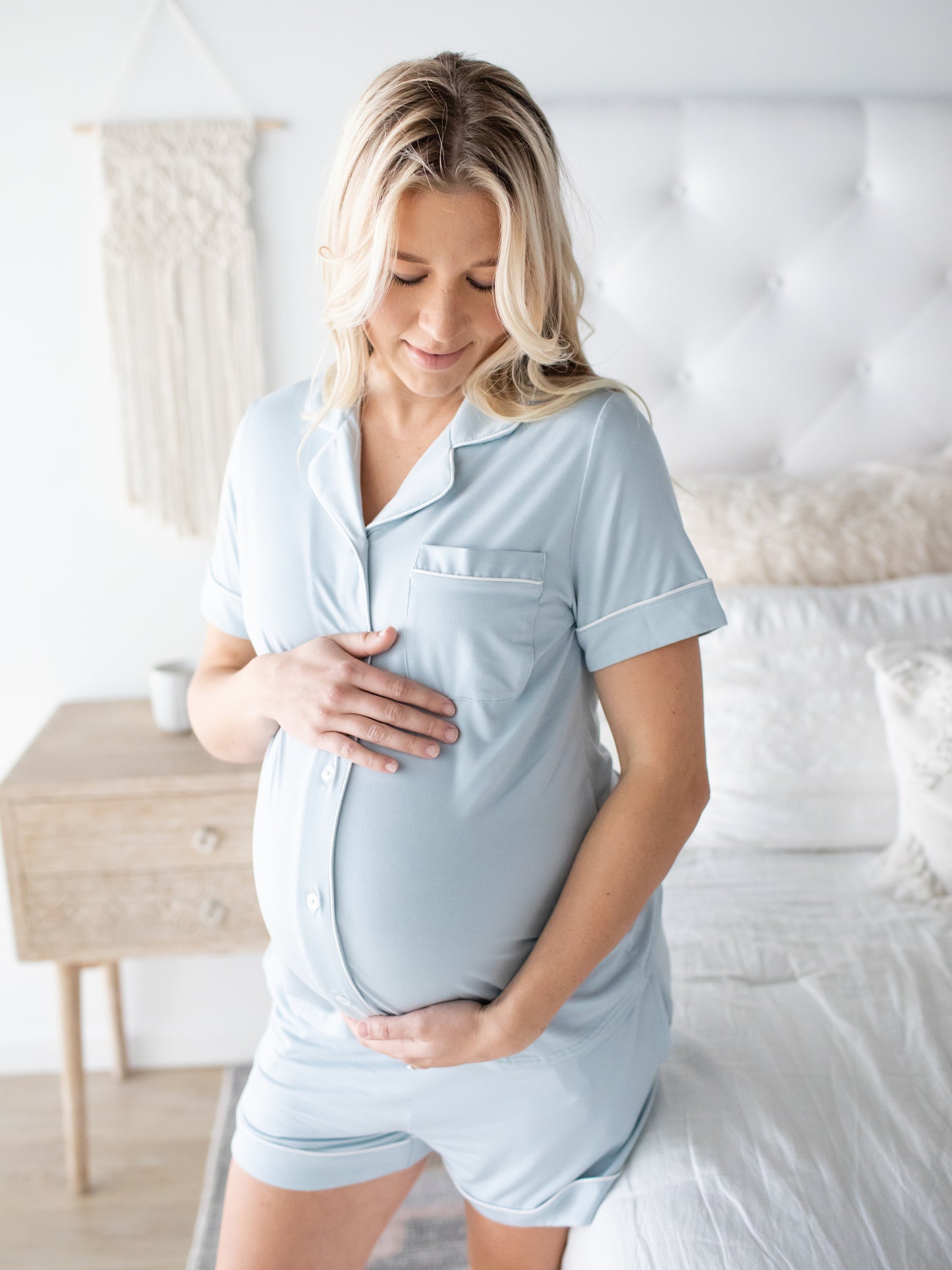 Pregnant model wearing the Clea Bamboo Short Sleeve Pajama Set in Mist  with her hand on her belly. @model_info:Taylor is wearing a Small.
