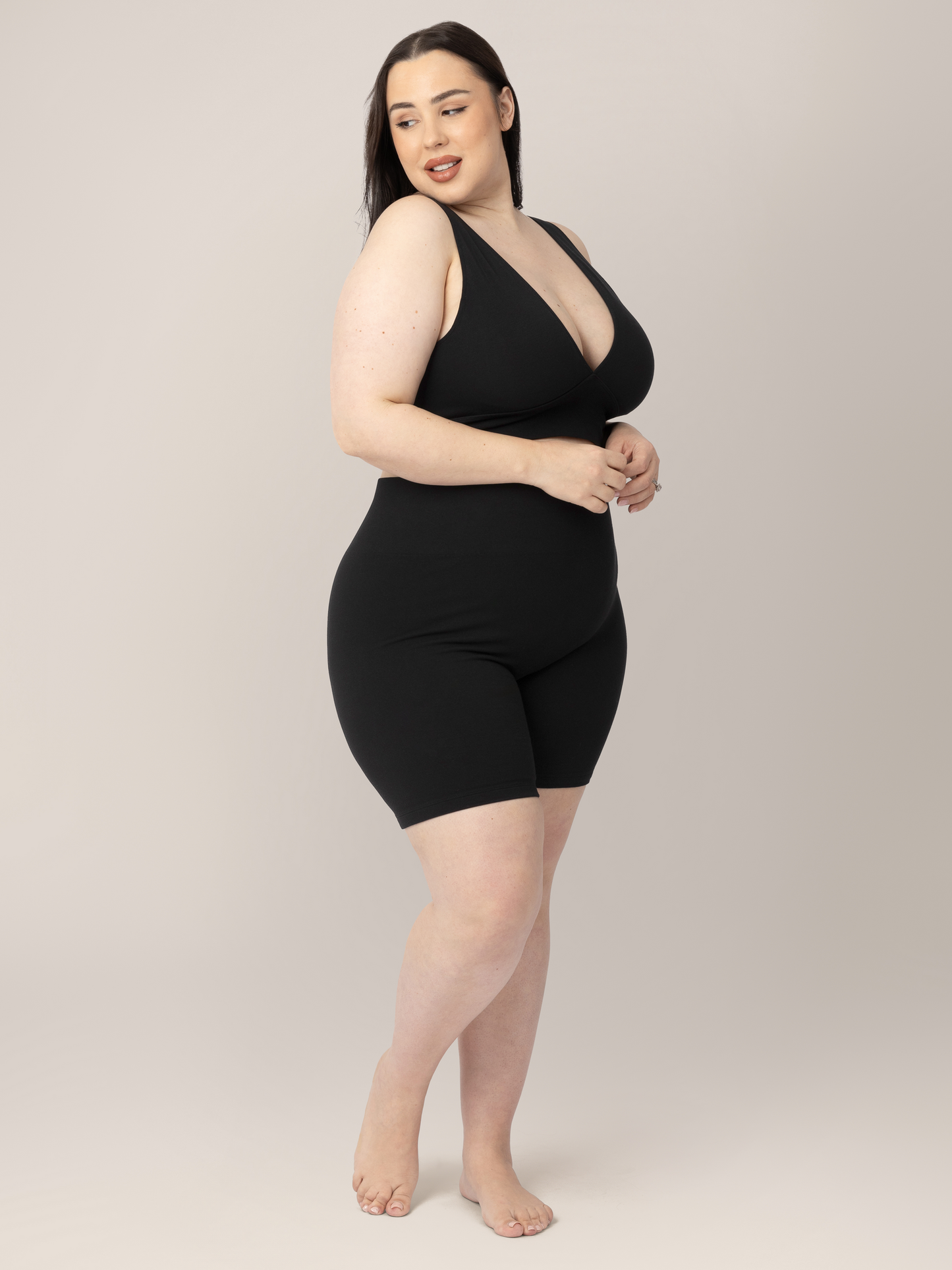 3/4 view of model wearing the Sublime® Bamboo Maternity & Postpartum Bike Short in Black, paired with the matching Sublime® Bamboo Maternity & Nursing Plunge Bra.