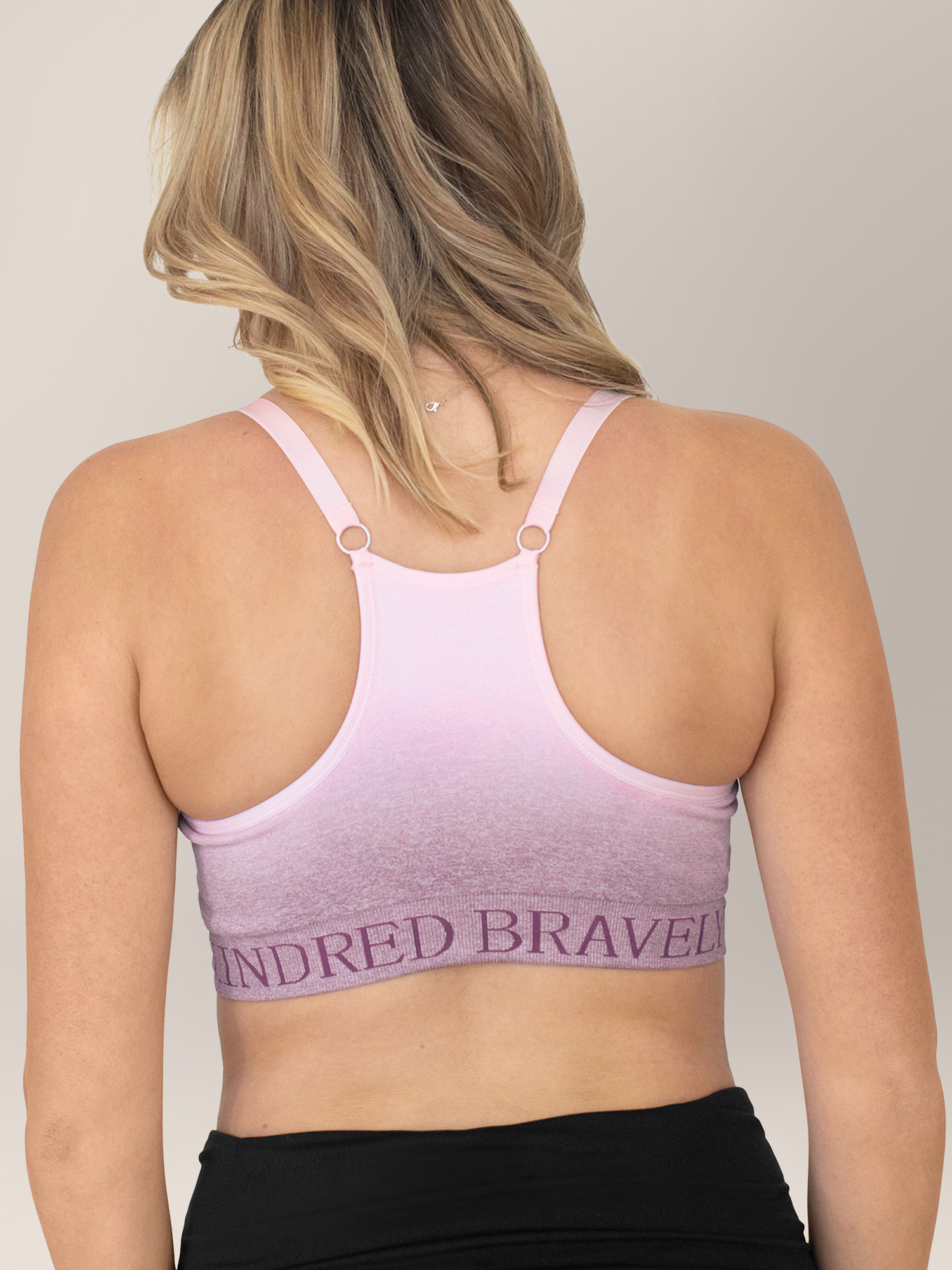 Back of a model wearing the Sublime® Hands-Free Pumping & Nursing Sports Bra in Ombre Purple.