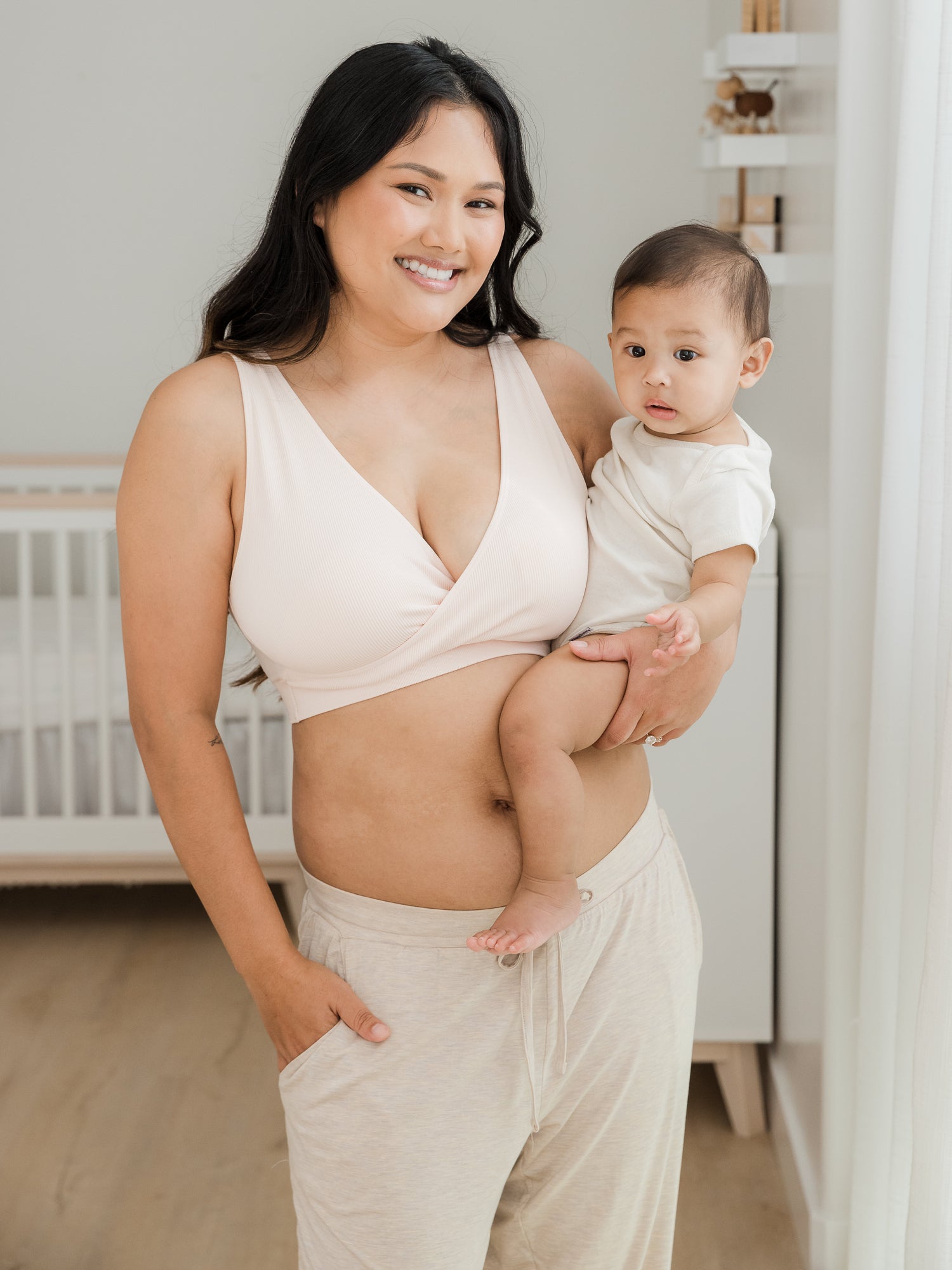 Model wearing the Everyday Lounge Jogger in Oatmeal Heather, holding her baby on her hip. @model_info:Binc is 5'5" and wearing a Medium Regular.