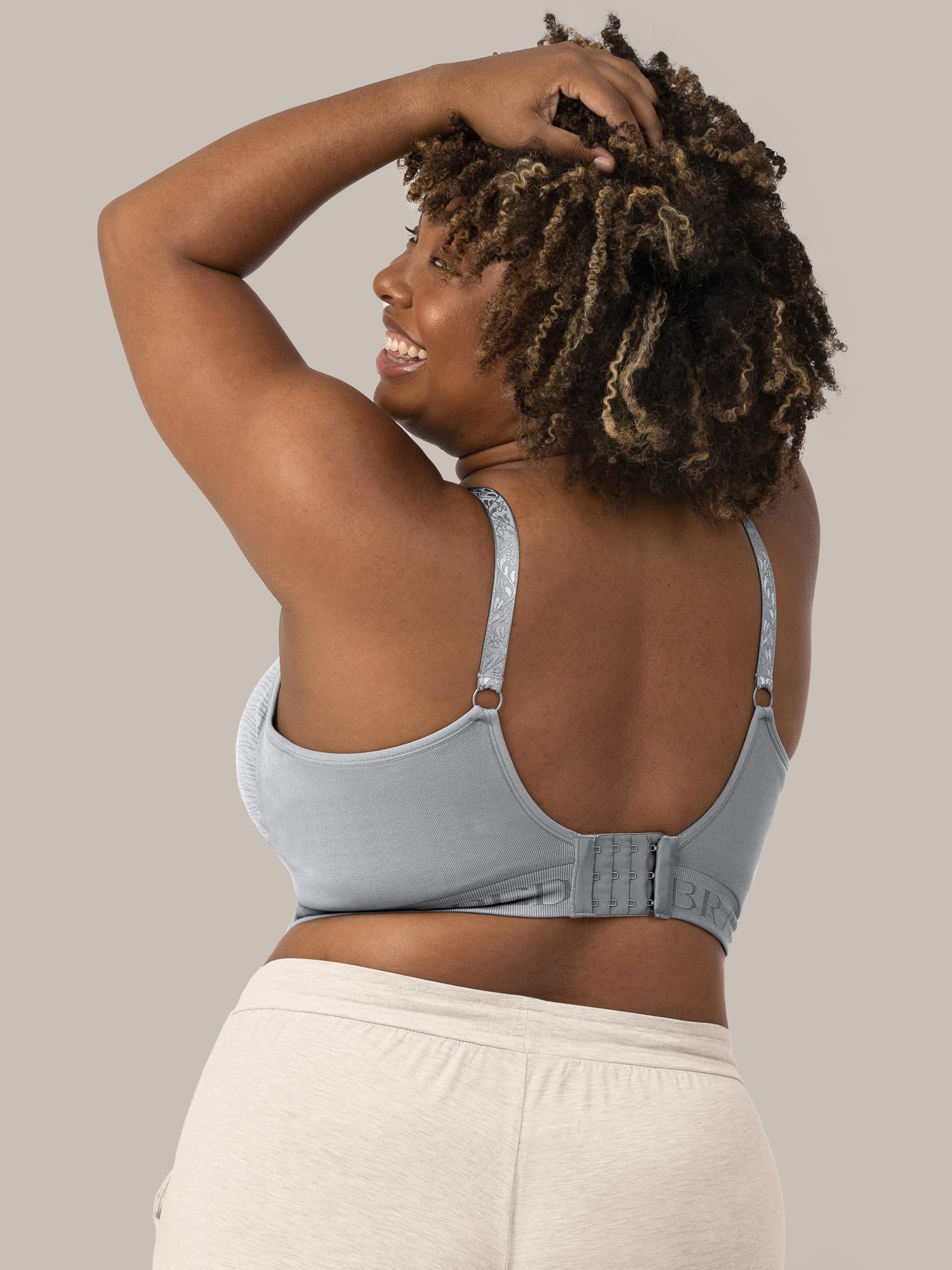 The back of a model wearing the Sublime® Hands-Free Pumping & Nursing Bra in Grey