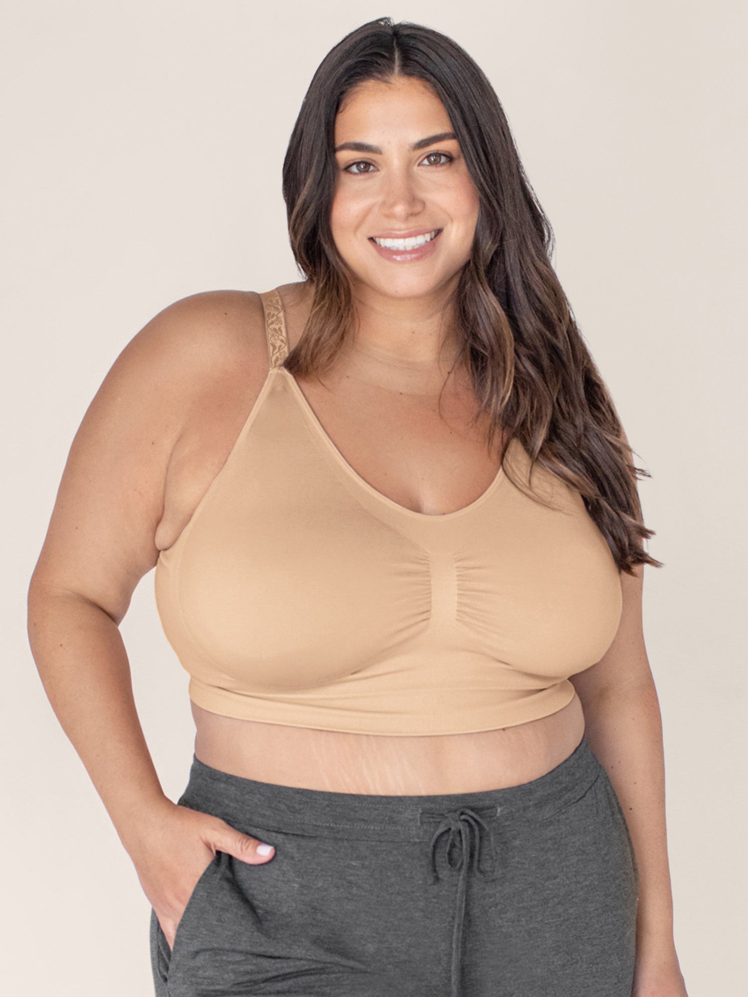 Model wearing the Nellie Sublime® Wireless Bra in Beige with her hand in her pocket. @model_info:Gia is wearing a 1X Busty.