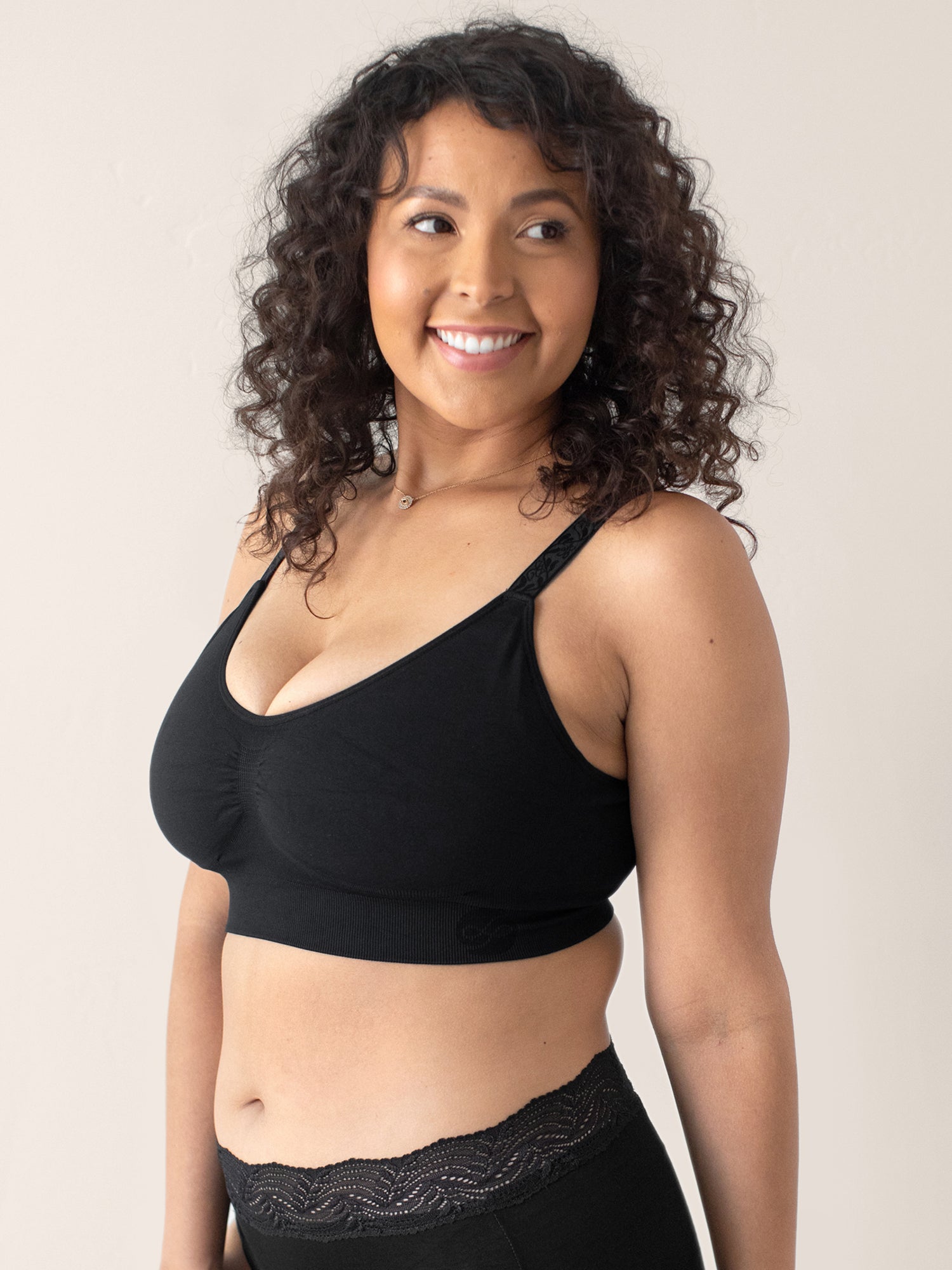 Front view of a model wearing the Nellie Sublime® Wireless Bra in Black with her hands at her sides. 