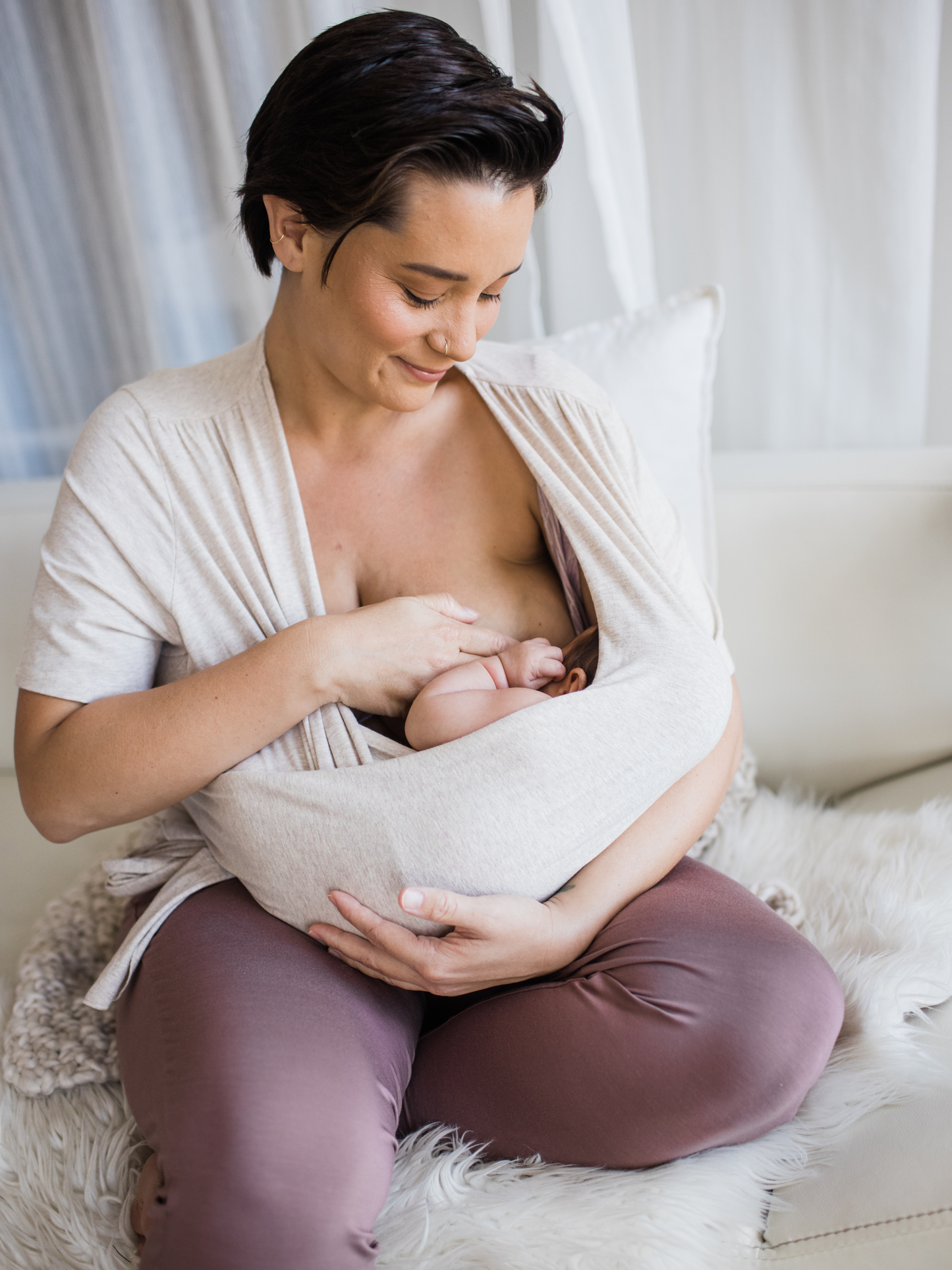 Model wearing the Organic Cotton Skin to Skin Wrap Top in Oatmeal Heather with her baby breastfeeding. 