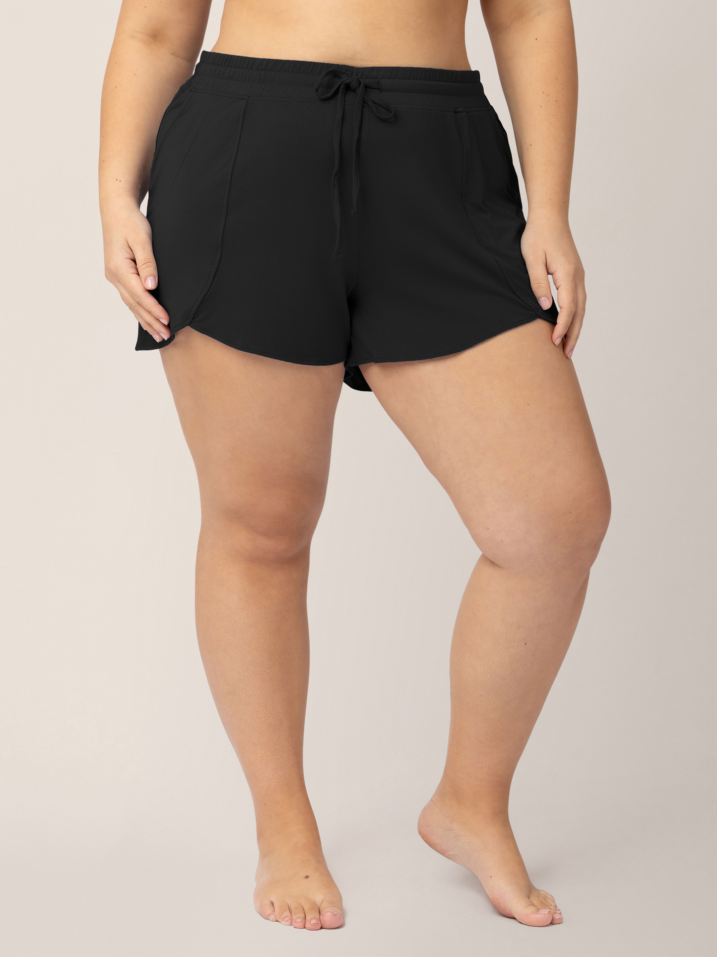 Closeup of the bottom half of a model wearing the Bamboo Maternity & Postpartum Lounge Short in Black