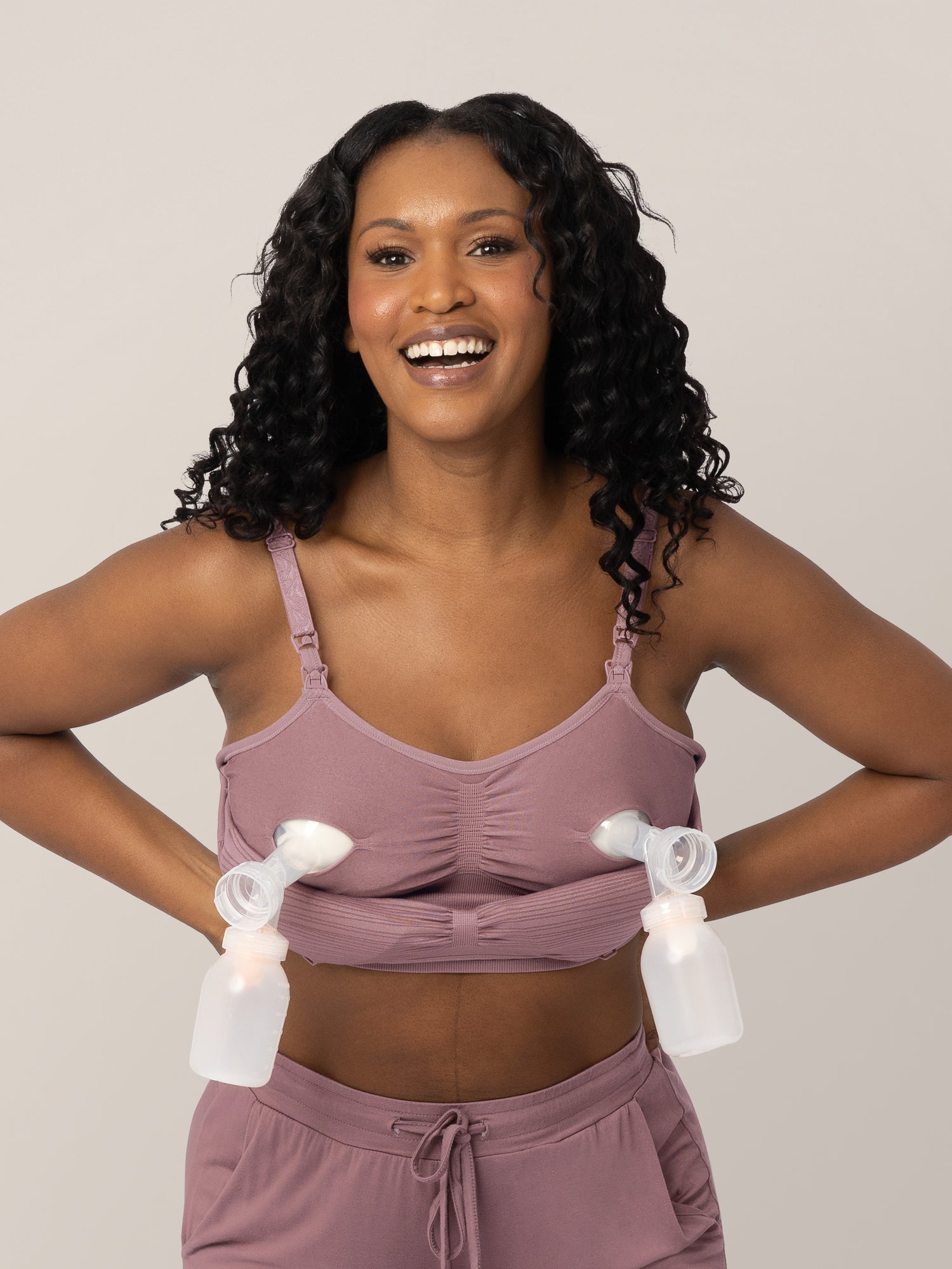 Front view of a model wearing the Sublime® Hands-Free Pumping & Nursing Bra in Twilight connected to two pumps