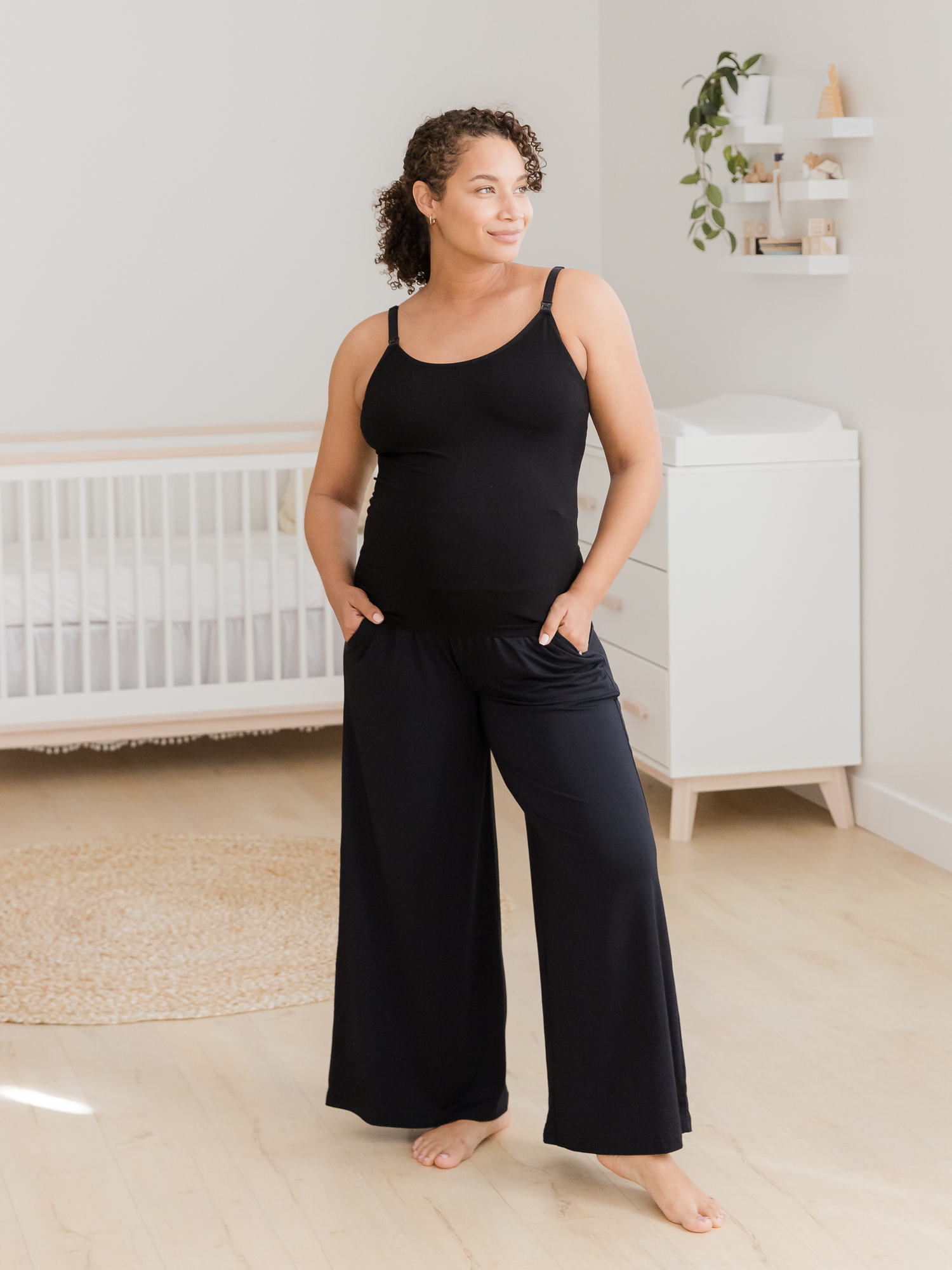 Front view of pregnant model wearing the Sublime® Bamboo Maternity & Nursing Camisole in black, paired with the Bamboo Wide Leg Maternity & Postpartum Lounge Pant.