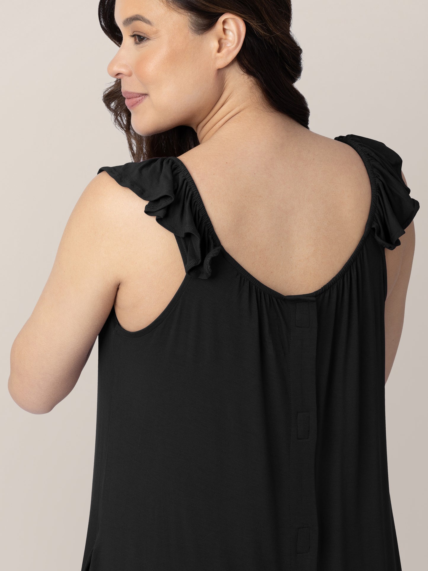 Back of a pregnant model wearing the Ruffle Strap Labor & Delivery Gown in Black