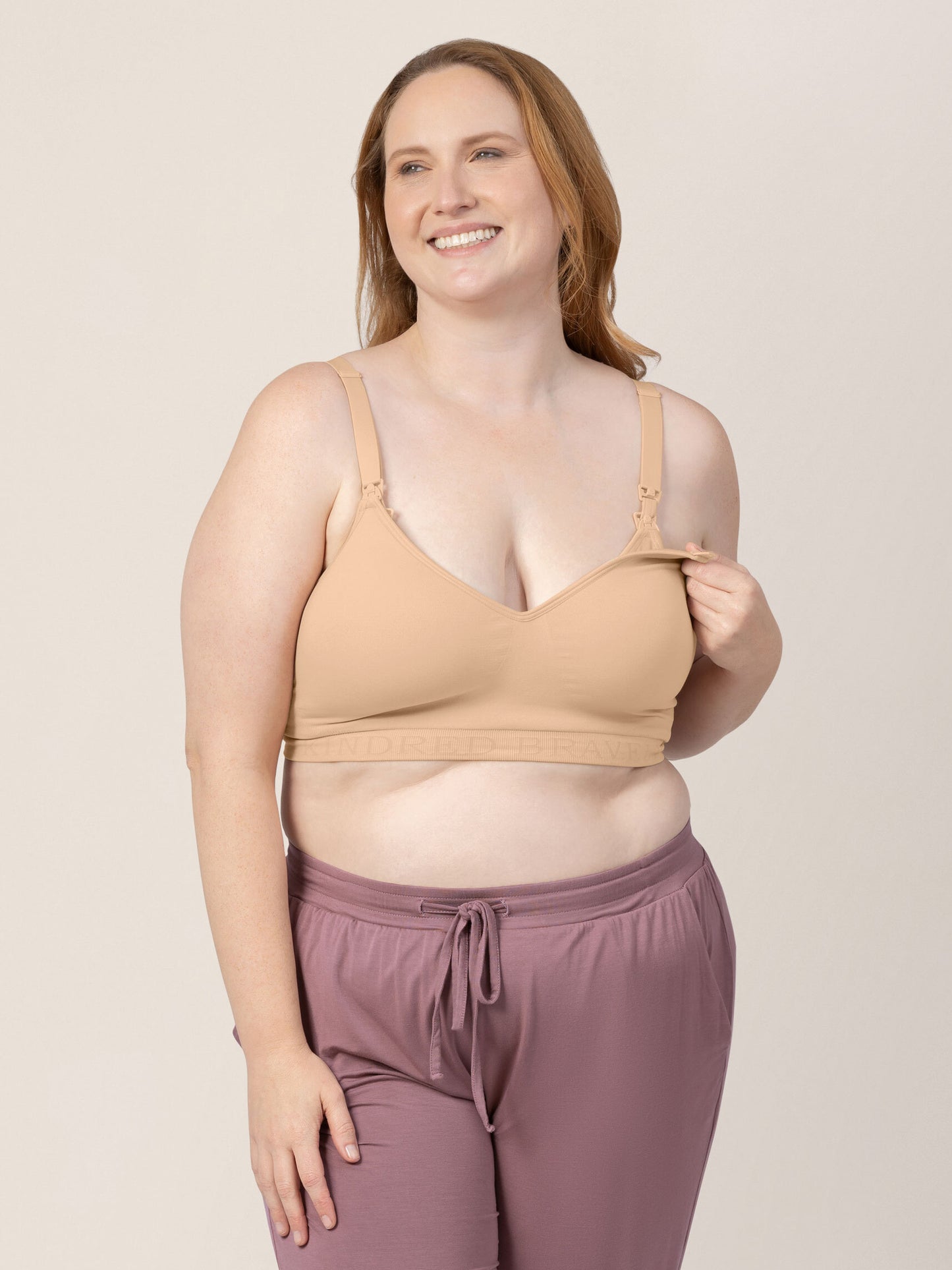Model wearing the Signature Sublime® Contour Hands-Free Pumping & Nursing Bra in Beige with her hand clip down nursing access.