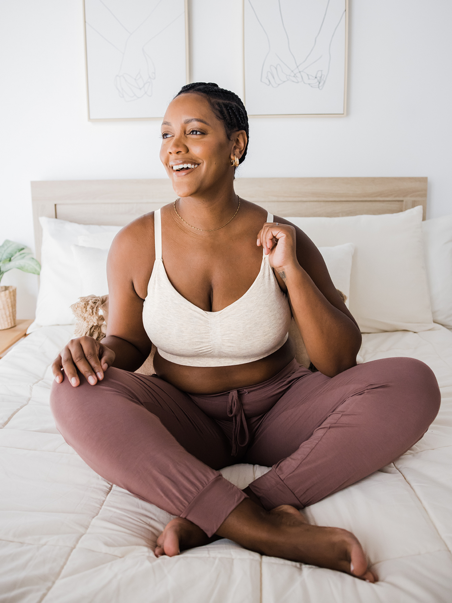 Model sitting on a bed while wearing the Sublime® Bamboo Hands-Free Pumping Lounge & Sleep Bra in Oatmeal Heather