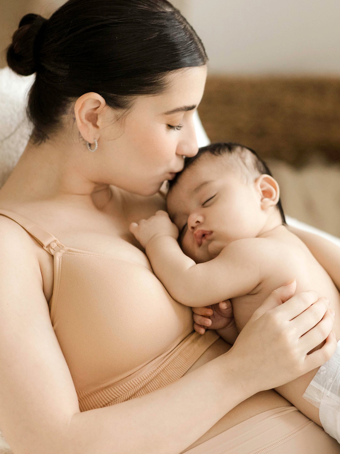 Model kissing her baby's head while wearing the Signature Sublime® Contour Maternity & Nursing Bra in Beige