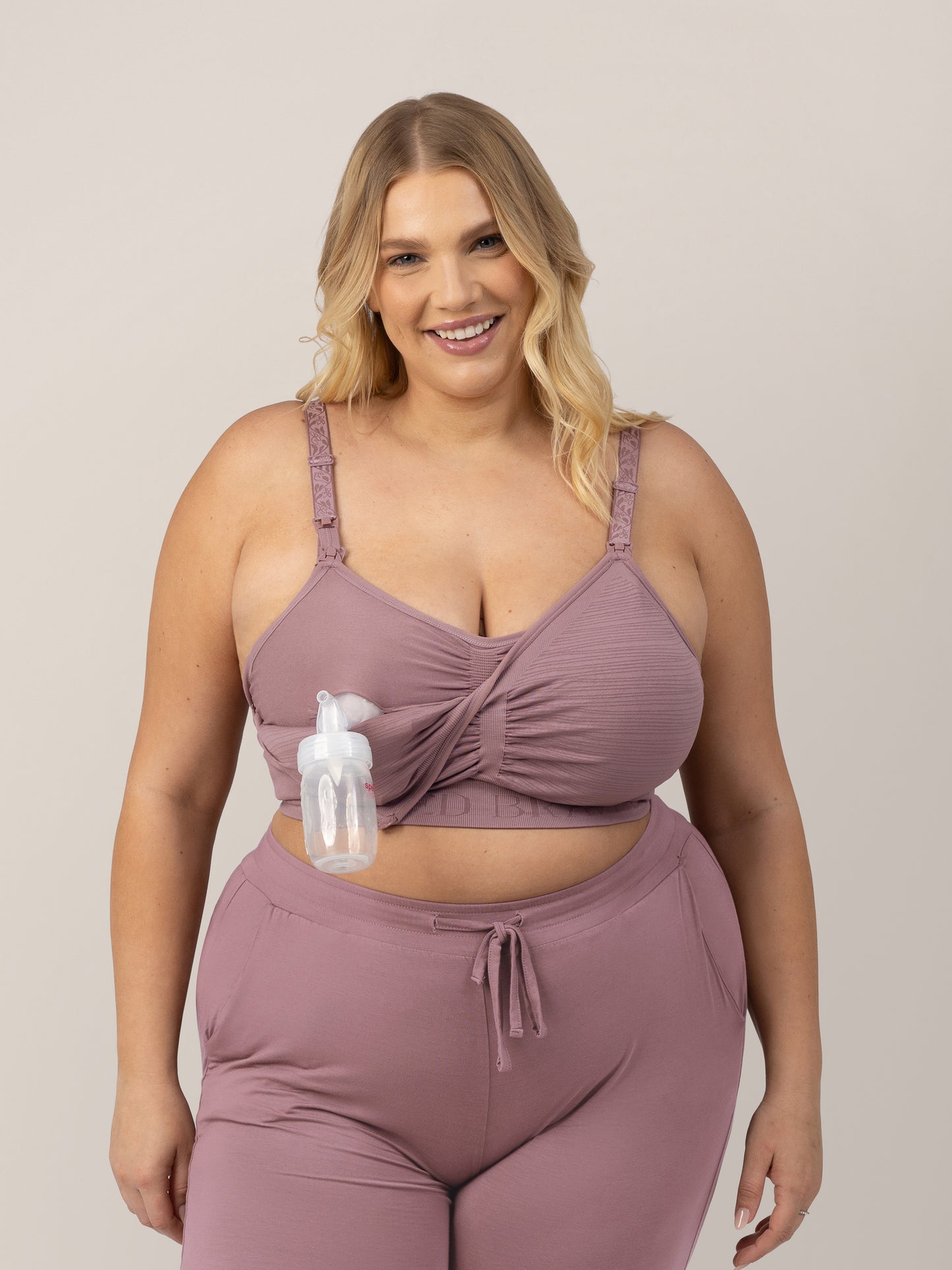 Model is wearing the Sublime® Hands-Free Pumping & Nursing Bra in Twilight connected to a pumping bottle