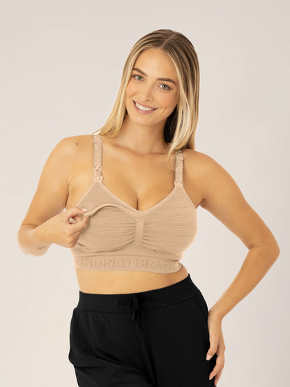 Busty model wearing the Sublime® Hands-Free Pumping & Nursing Bra in Beige demonstrating the clipdown access