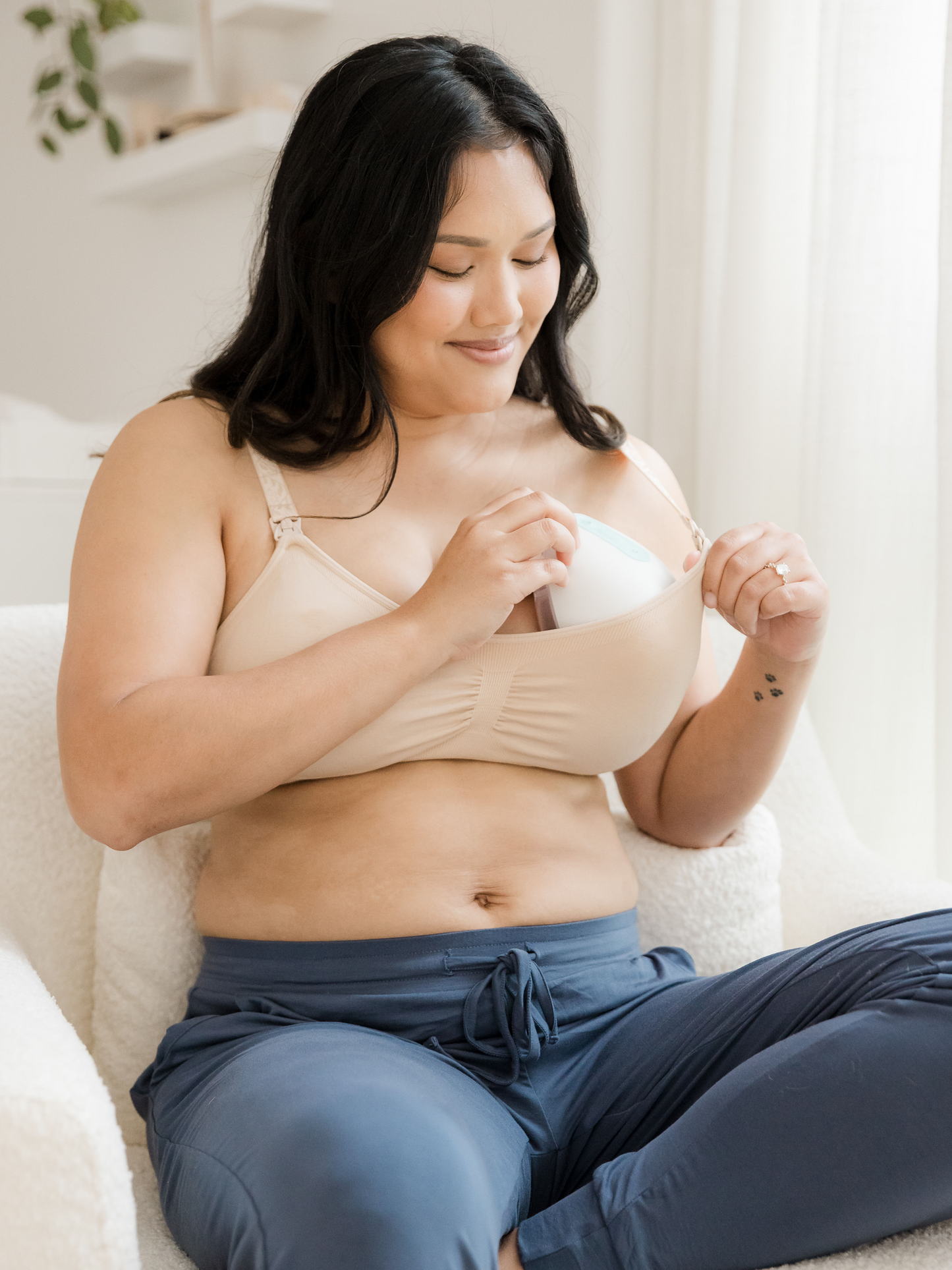 Model putting on a breast pump into the Simply Sublime® Nursing Bra in Beige