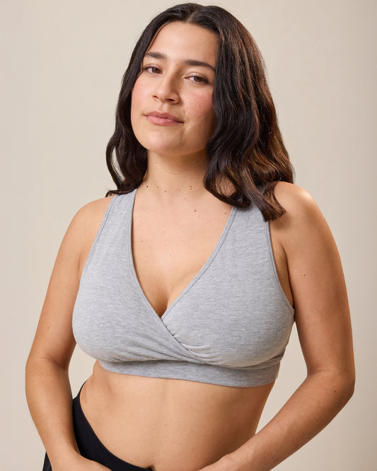 Woman wearing the French Terry Racerback Nursing & Sleep Bra in grey heather against a beige background@model_info:Linda is wearing a Busty Medium.