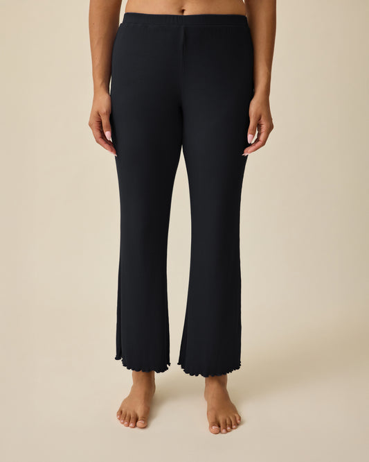 Model is wearing Ribbed Modal Lounge Pant in Black on a beige background. @model_info:Mei is 5'8" and wearing Small.
