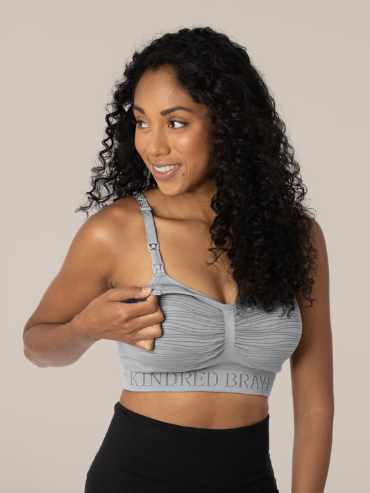 Model wearing the Sublime® Hands-Free Pumping & Nursing Brain in Grey, demonstrating the clip down access on the bra. @model_info:Anastacia is wearing a Small.