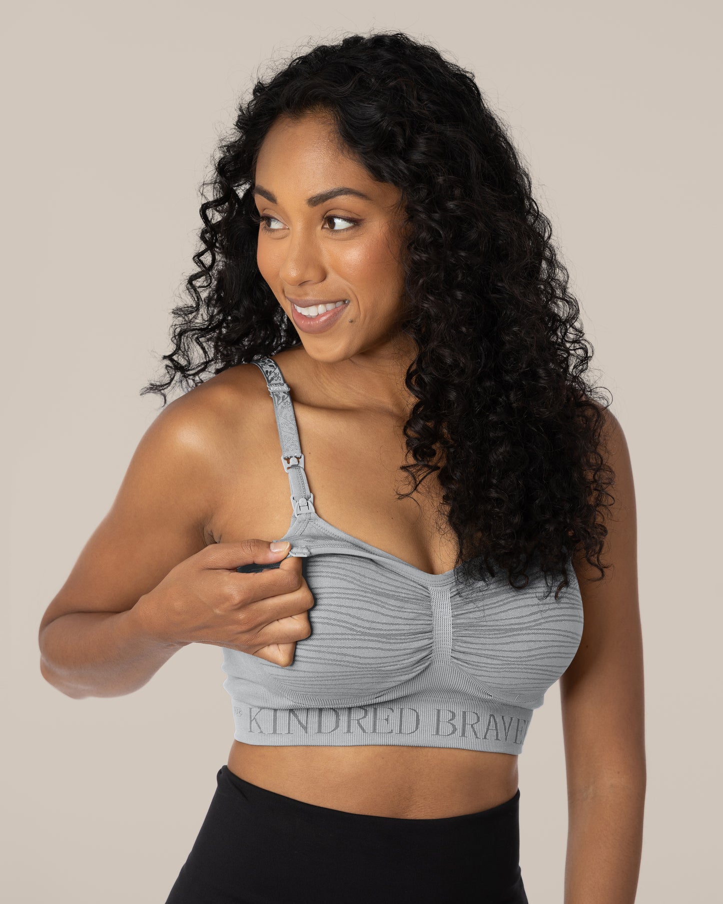 Model wearing the Sublime® Hands-Free Pumping & Nursing Brain in Grey, demonstrating the clip down access on the bra. @model_info:Anastacia is wearing a Small.