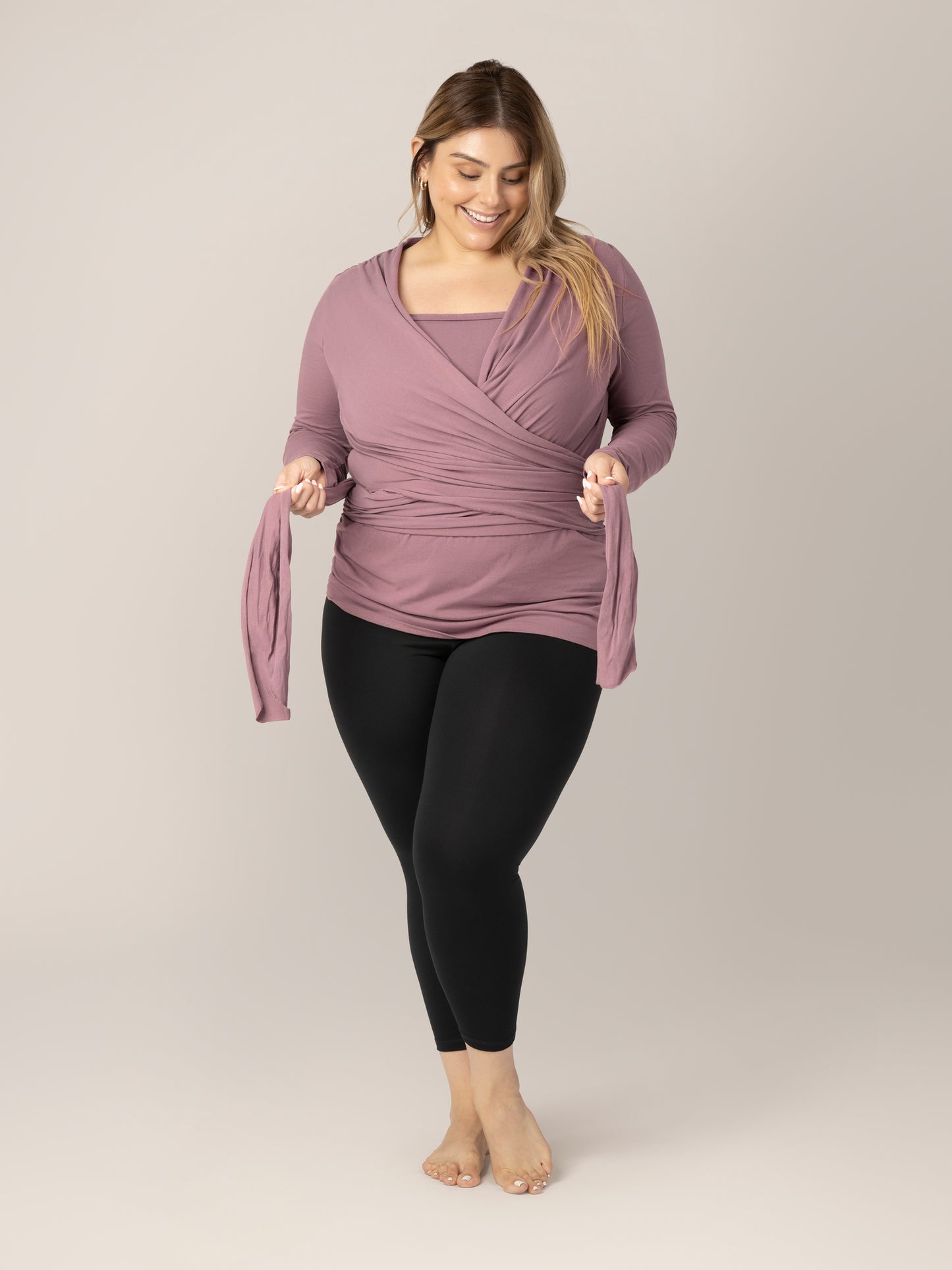 Model wearing the Organic Cotton Skin to Skin Long Sleeve Wrap Top in Twilight, wrapping the straps around her torso