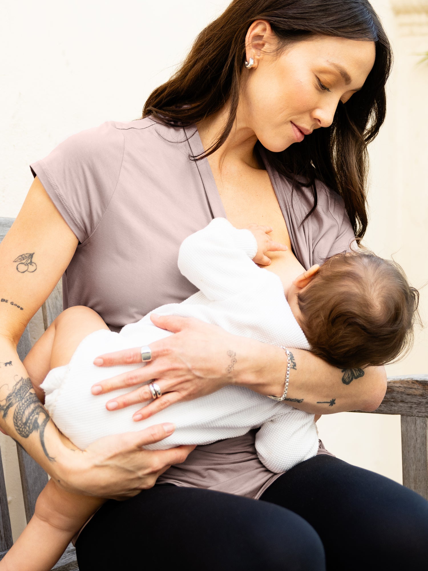 Model sitting and nursing baby, wearing the Bamboo Draped Nursing Top in lilac stone