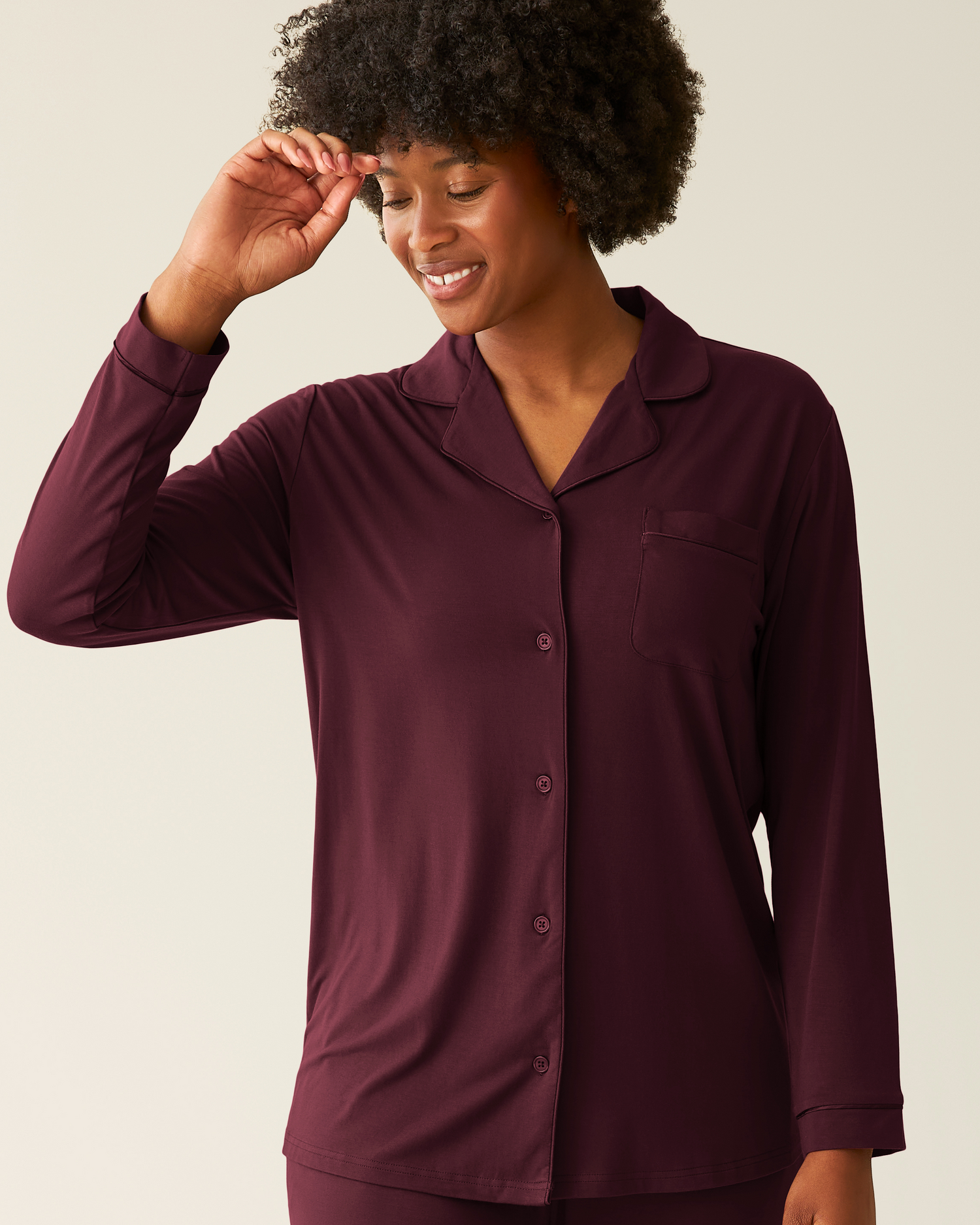 Cropped in image of woman wearing the Clea Bamboo Long Sleeve Pajama Set in Deep Burgundy, showing top of set