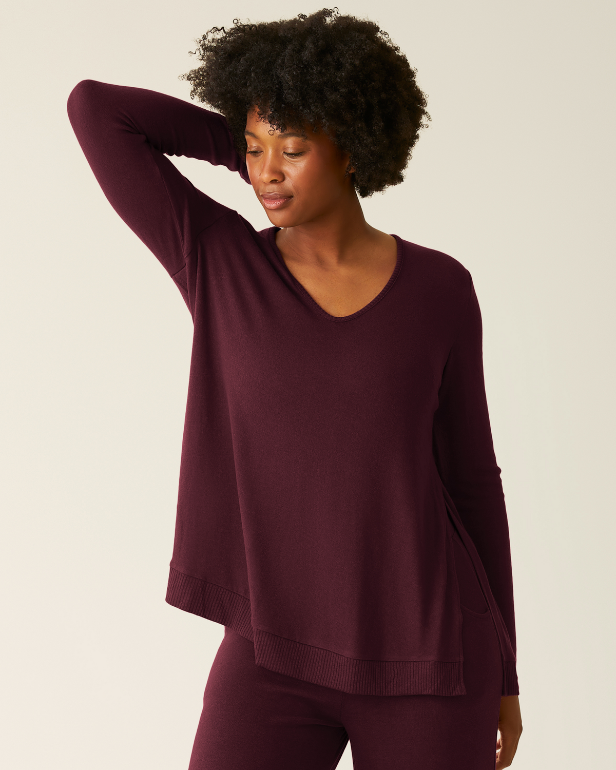 Front view of model wearing CozyKnit Maternity & Nursing V-neck Top in Deep Burgundy with CozyKnit Wide Leg Lounge Pant in Deep Burgundy on a beige background.