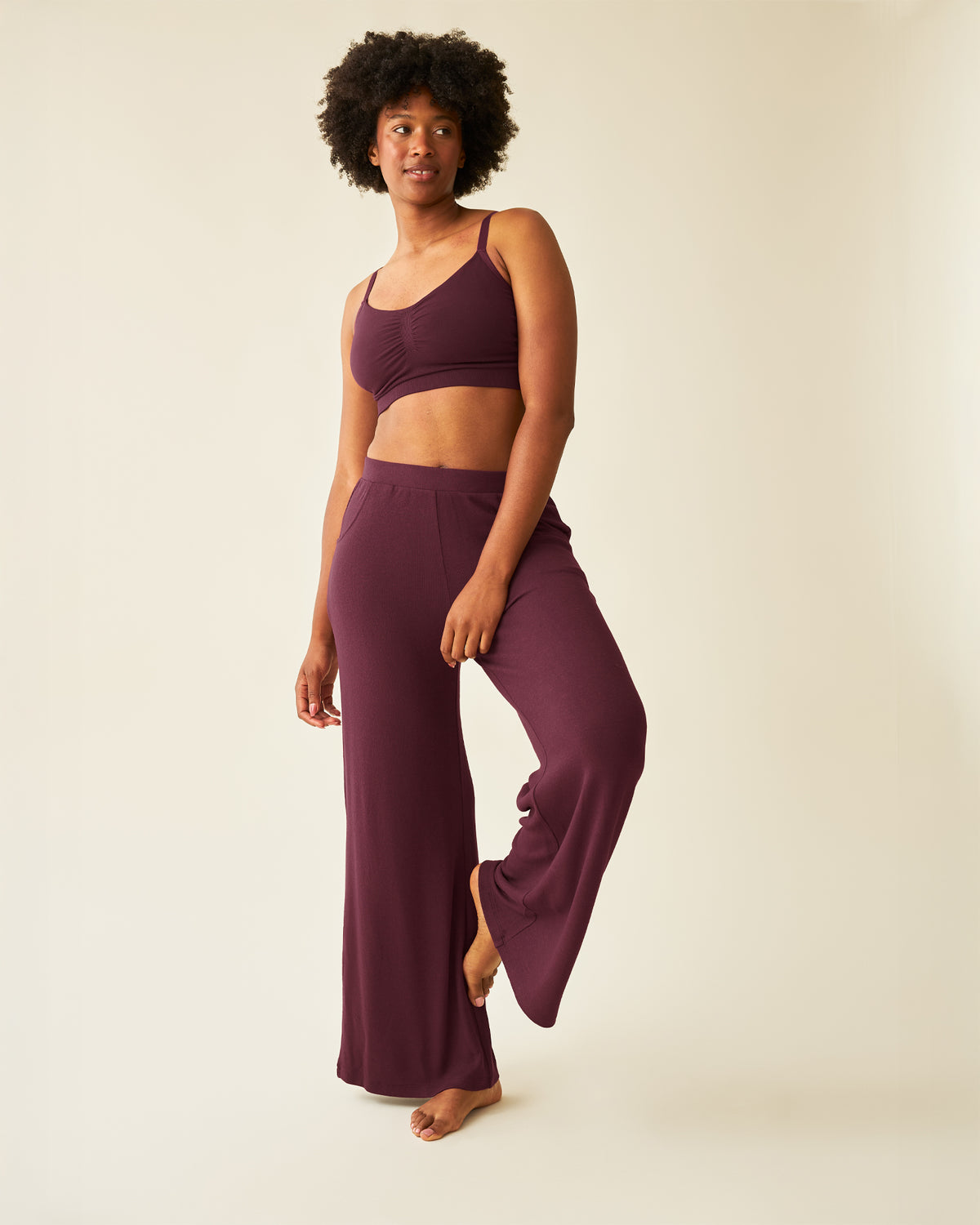 Woman wearing the CozyKnit Wide Leg Lounge Pant in Deep Burgundy, paried with matching bra