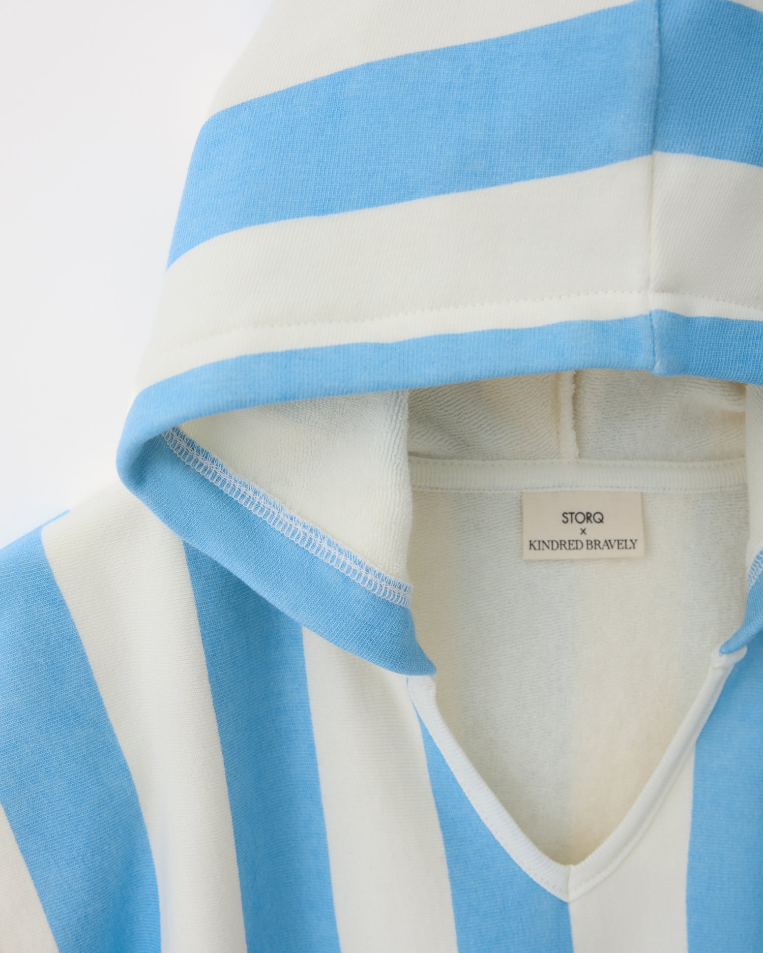 Close up of hood on Toddler Poncho Towel in Blue Wide Stripe on a beige background