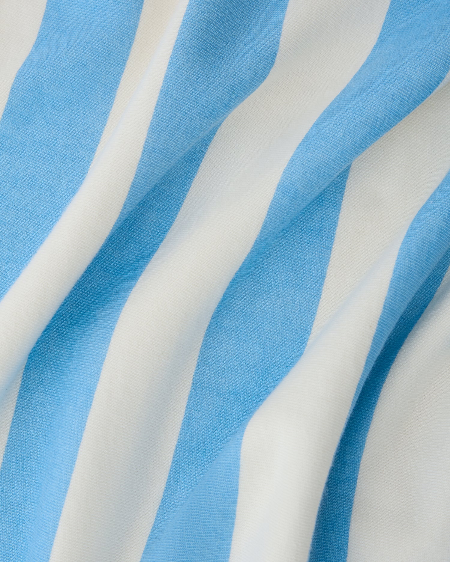 Close up of pattern on Toddler Poncho Towel in Blue Wide Stripe on a beige background