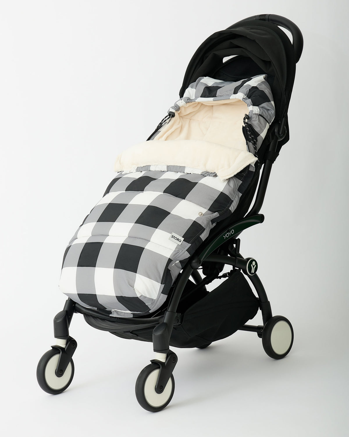 Cozy Stroller Footmuff in Buffalo Plaid set in a black stroller on an off white background.