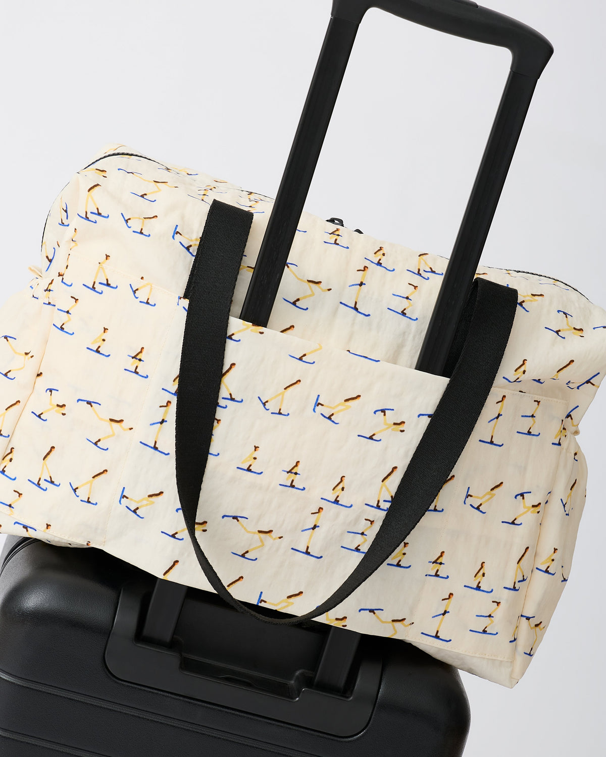Large Weekender Bag in Ivory Ski is set ontop of a suitcase, on an off white background.
