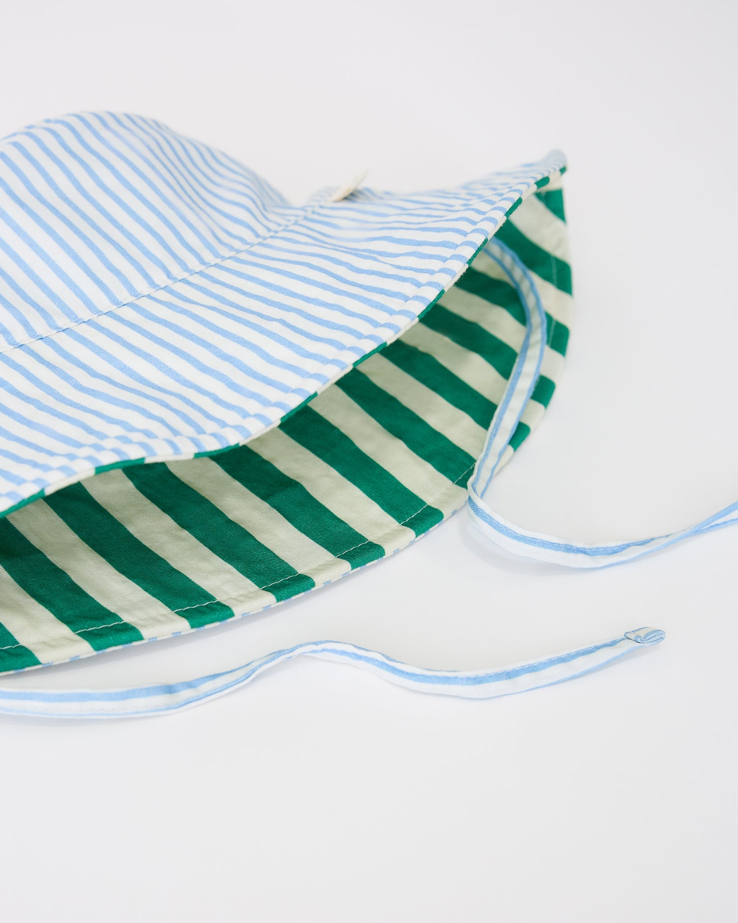 Close up of reverse pattern on Toddler Sun Hat in Blue Pinstripe on a beige background