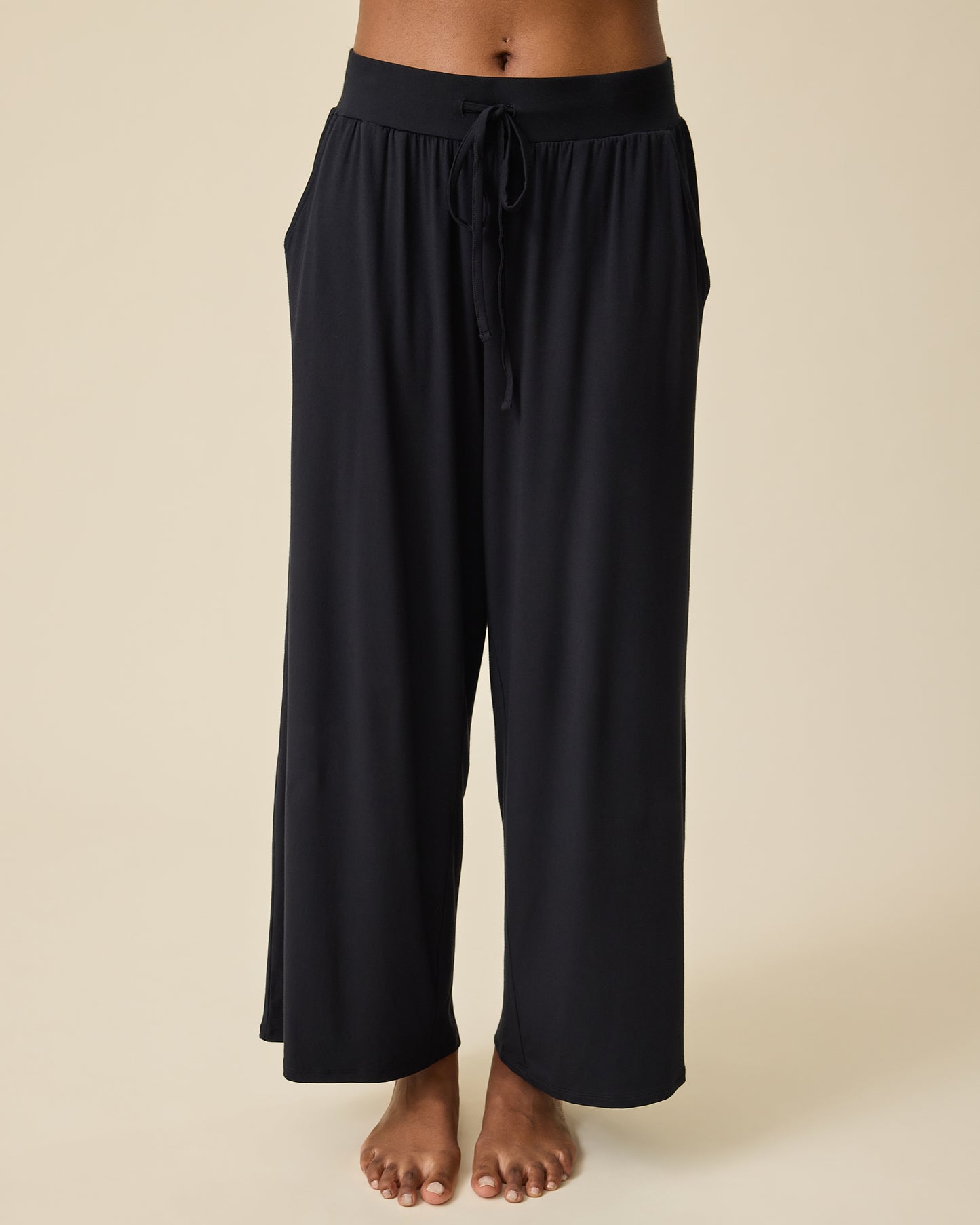 Wide-leg Aria Bamboo Casual Lounge Pant in black worn by a person on a beige background