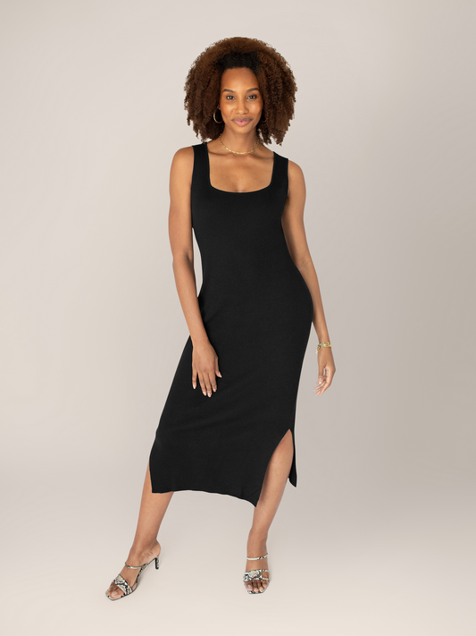 Model wearing the 2-in-1 Maternity & Nursing Midi Dress in Black with her hands at her sides.@model_info:Elaina is 5'9" and wearing a Small.
