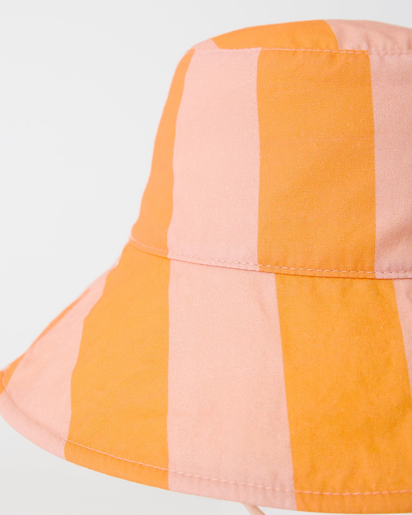 Close up view of Toddler Sun Hat in Pink Wide Stripe on a beige background