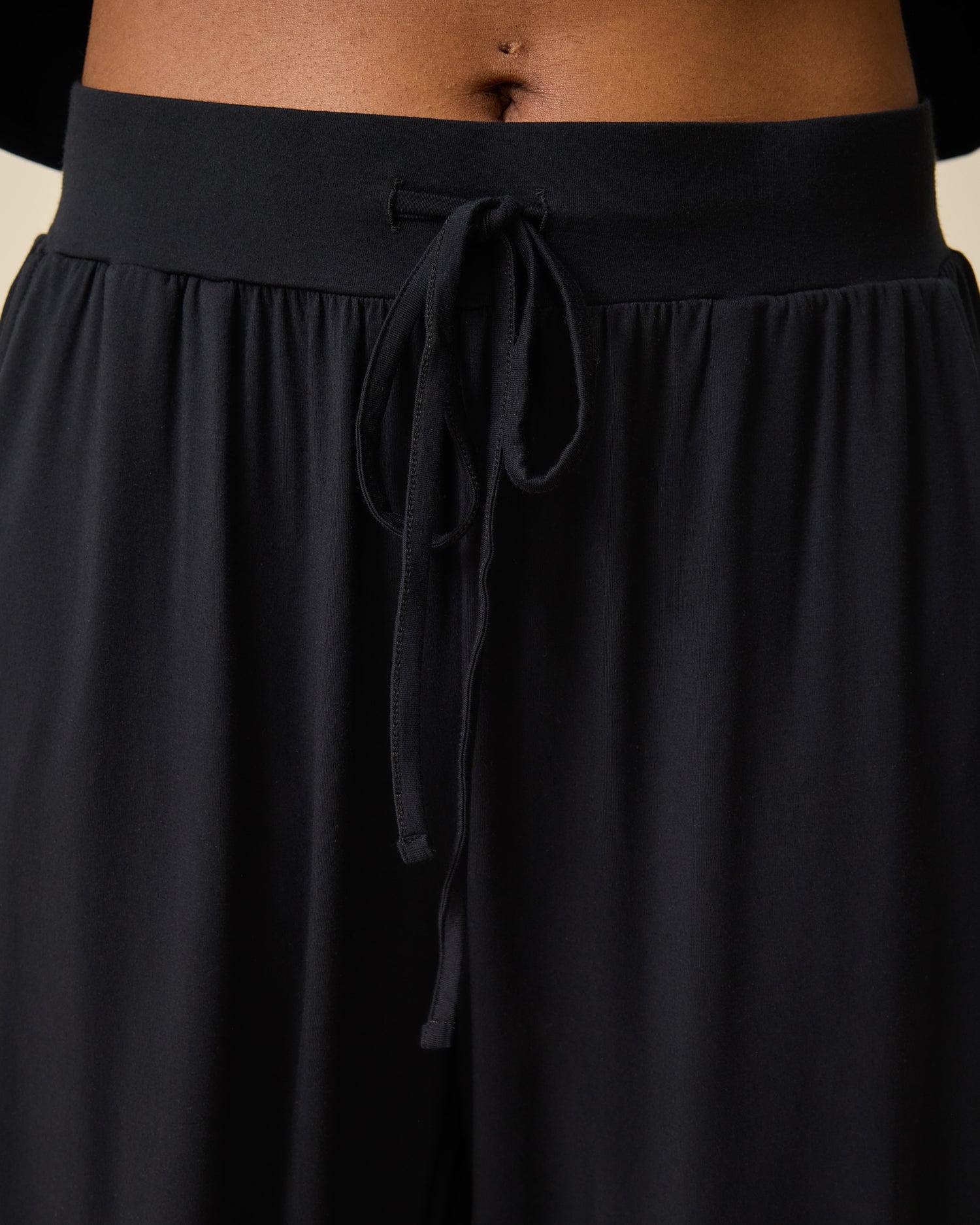 Close up of waistband and drawstring on the Aria Bamboo Casual Lounge Pant  in black on person on beige background