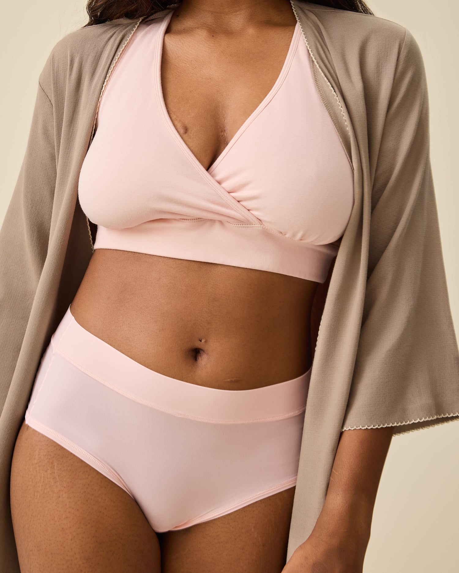 Model is wearing Grow with Me™ Maternity & Postpartum Brief in Soft Pink  with Cotton Bamboo Robe in Taupe, on a beige background