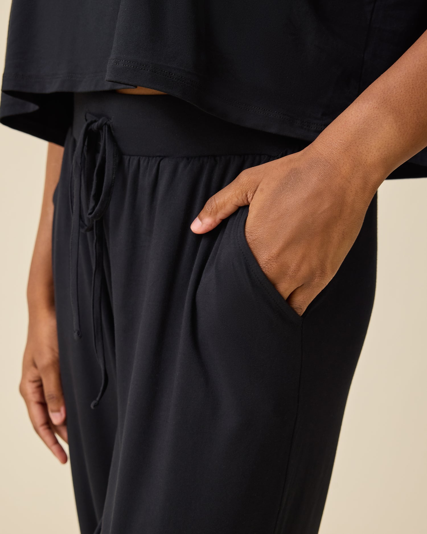 Close up of pocket and waistband on the Aria Bamboo Casual Lounge Pant  in black on person on beige background