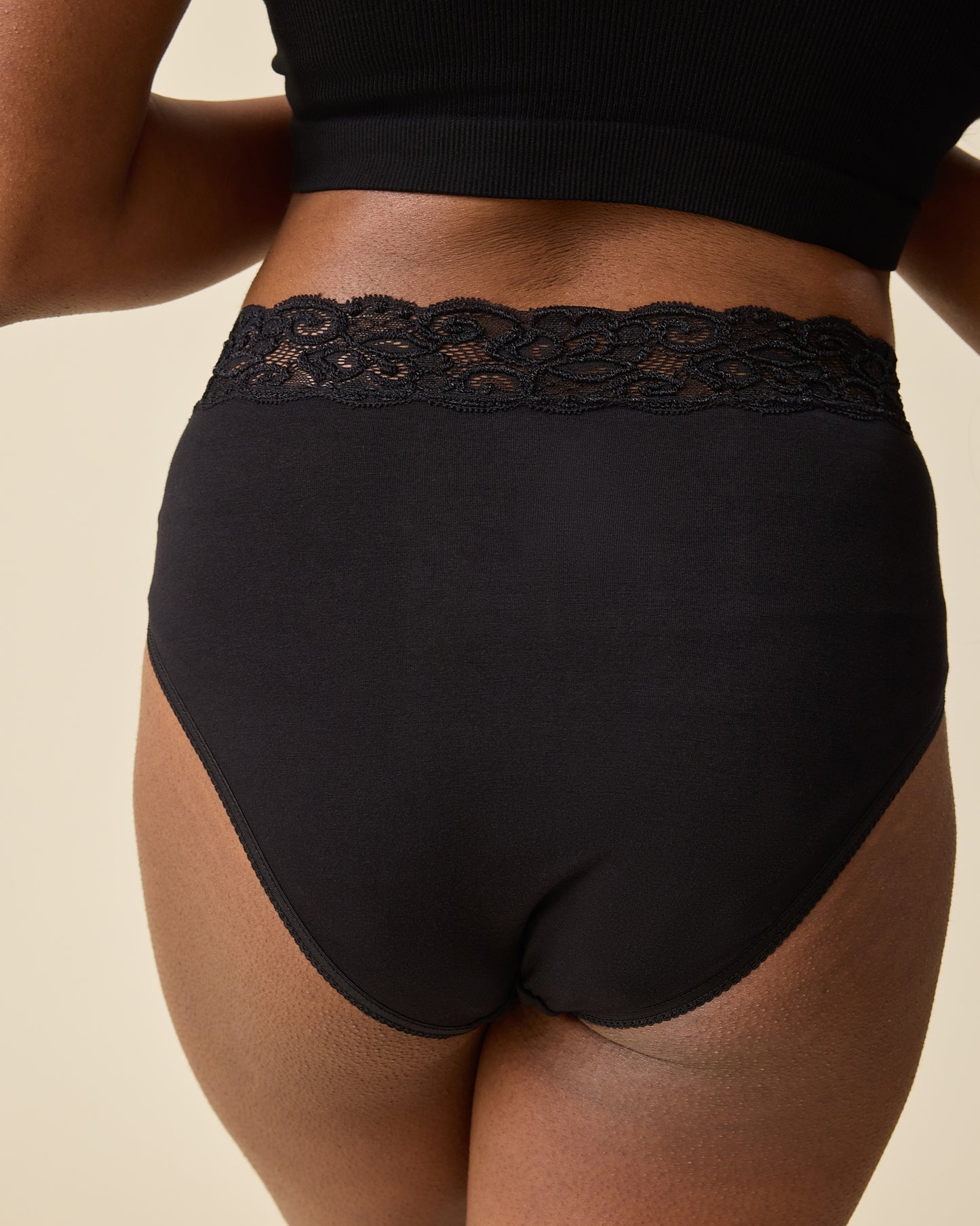 Back view of model wearing High-Waisted Postpartum Underwear Pack in Assorted Neutrals on a beige background