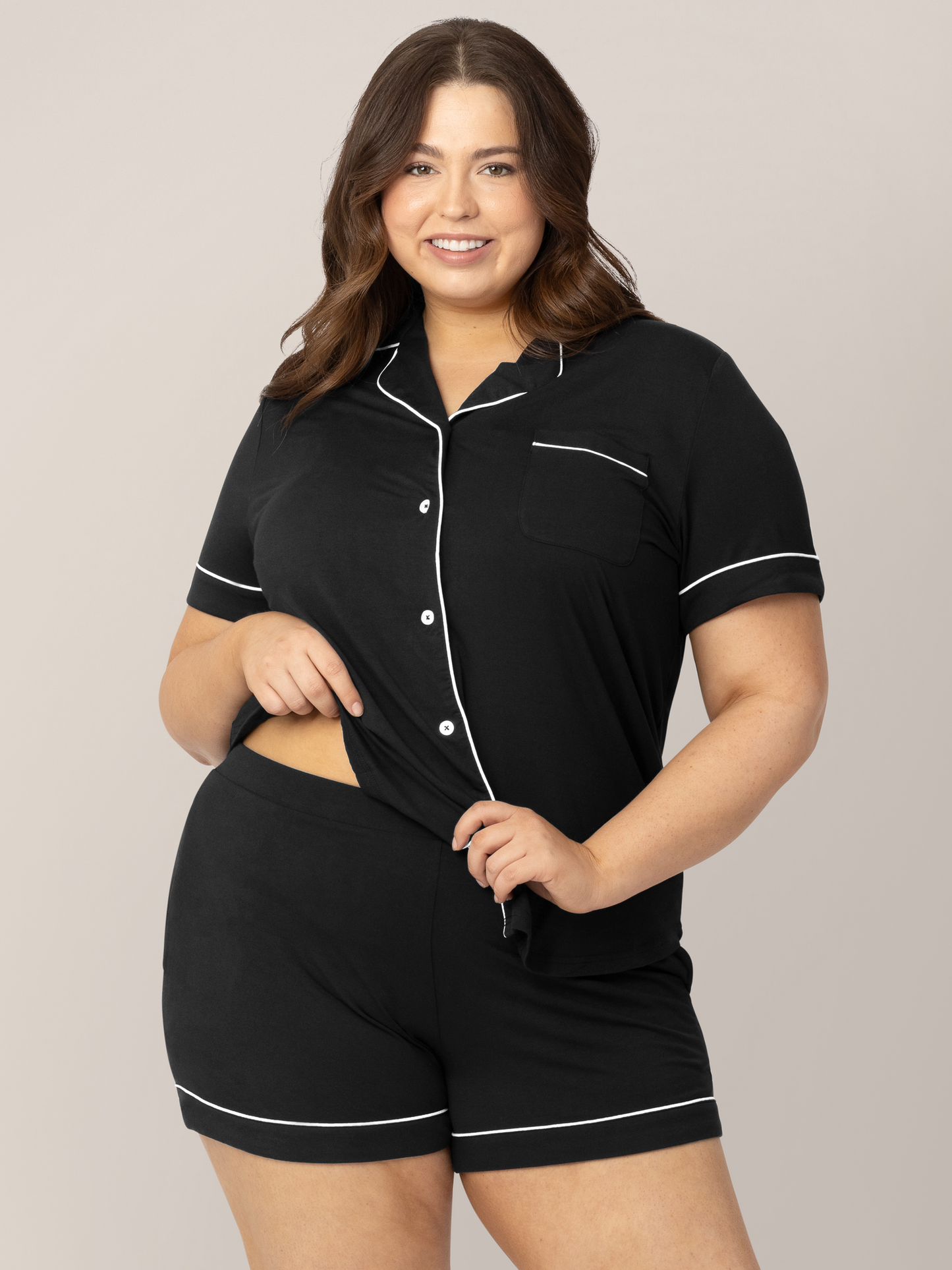 Model wearing the Clea Bamboo Short Sleeve Pajama Set in Black holding onto the waistband. 