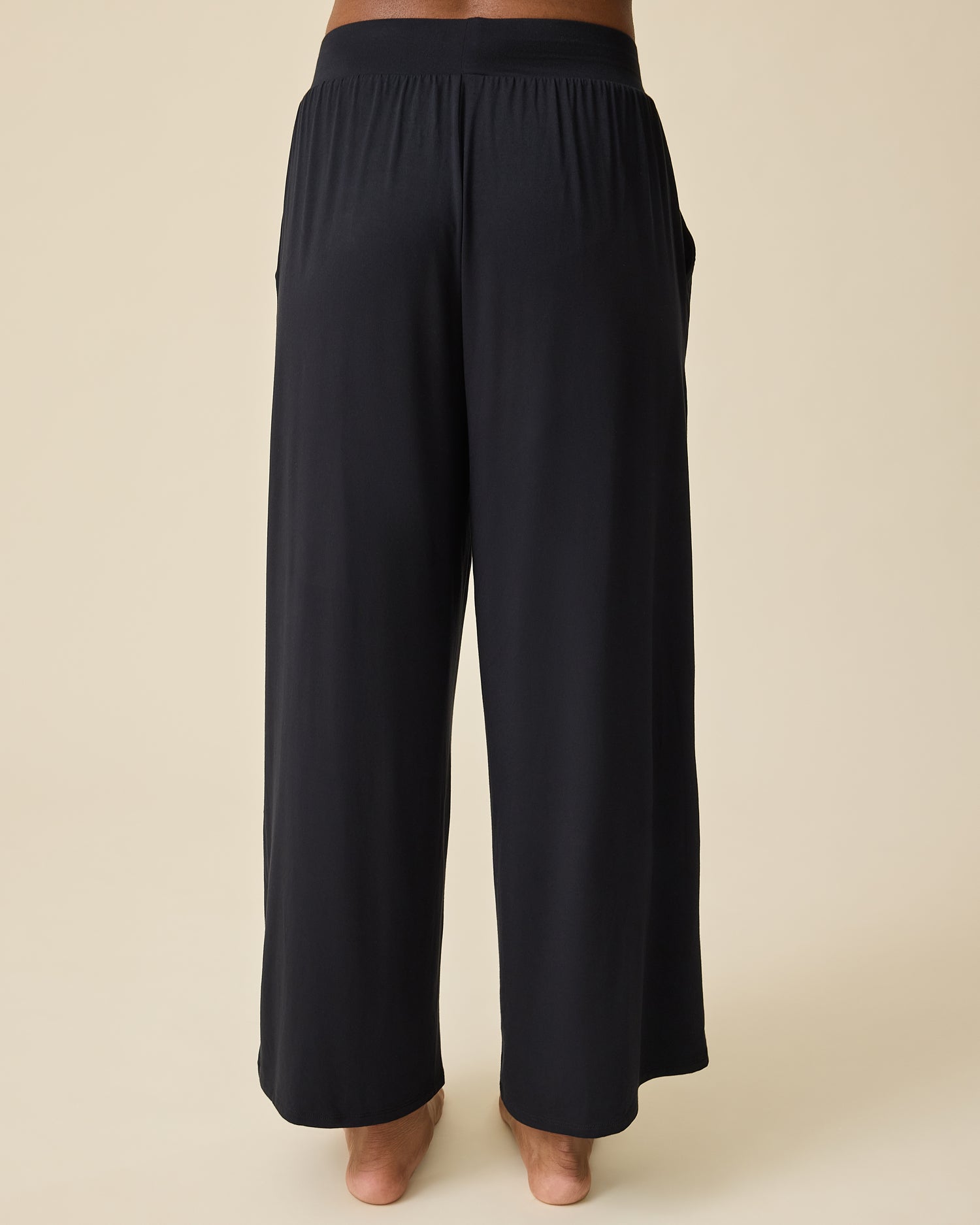 Woman wearing the Aria Bamboo Casual Lounge Pant in black on beige background