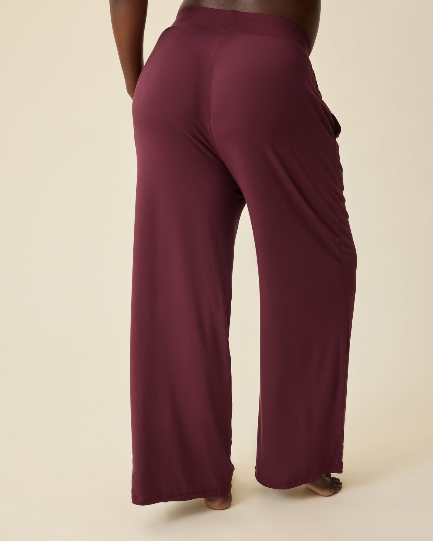 Back view of Aria Bamboo Casual Lounge Pant in Deep Burgundy on a beige background.