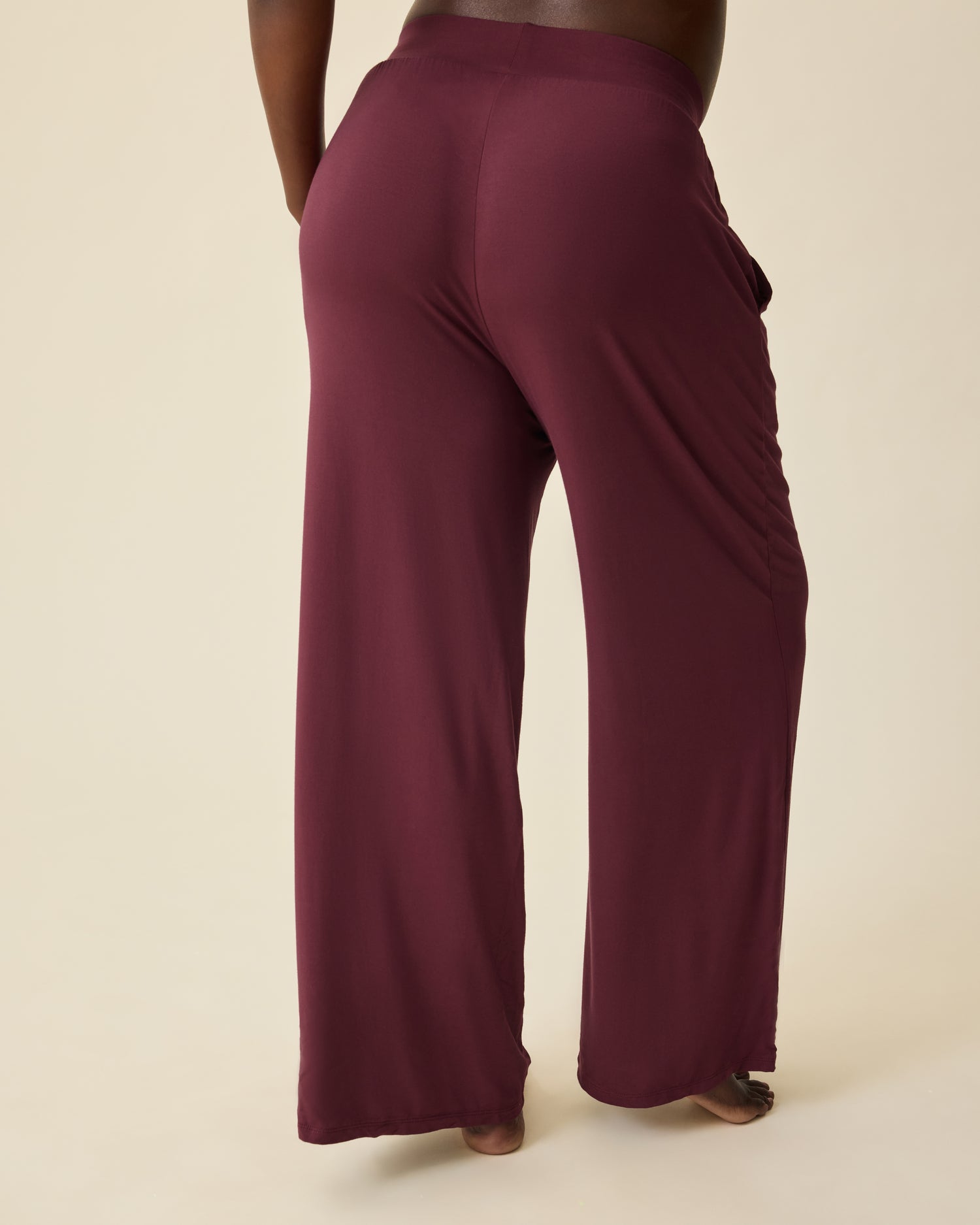 Back view of Aria Bamboo Casual Lounge Pant in Deep Burgundy on a beige background.