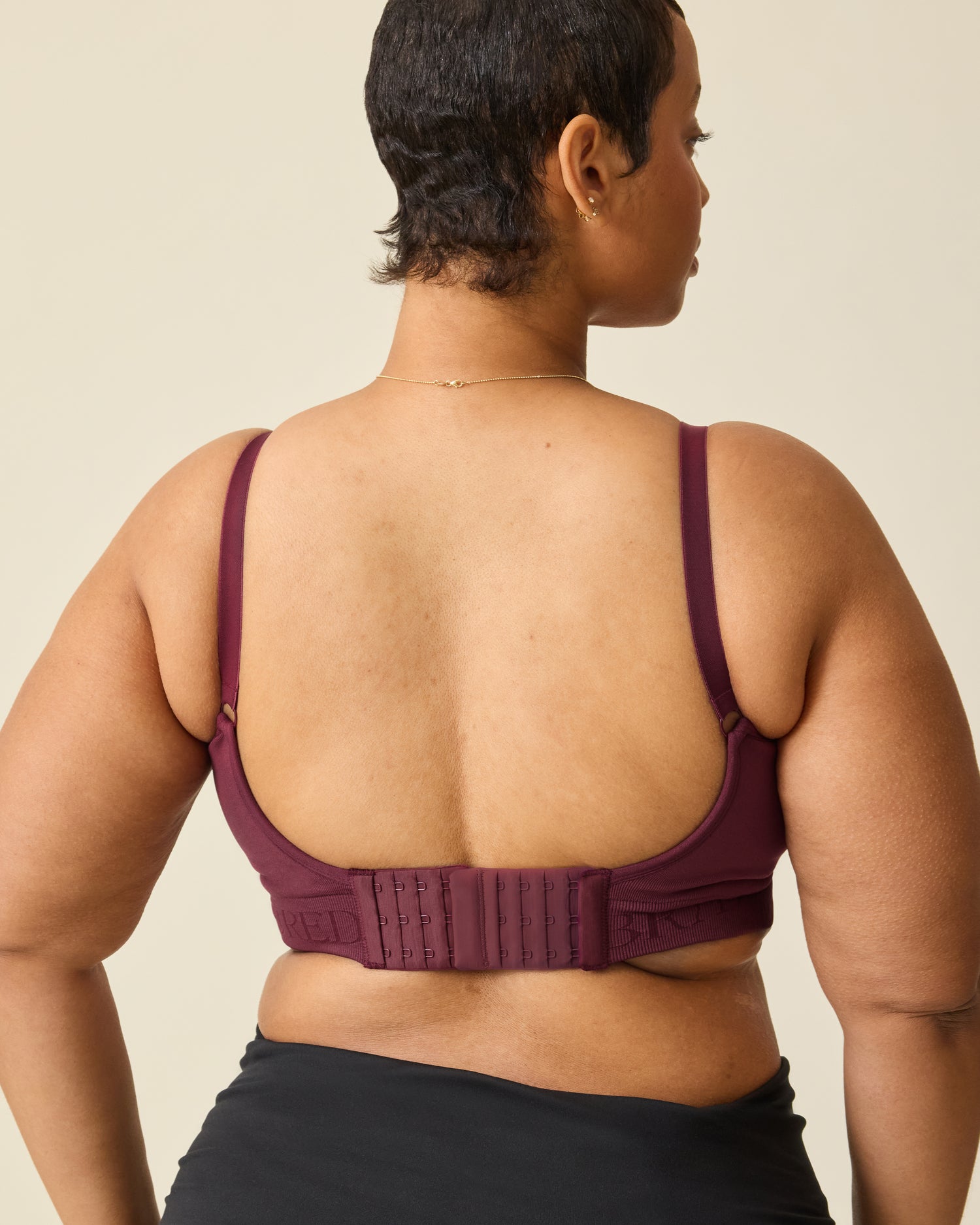 Back view on Sublime® Hands-Free Pumping & Nursing Bra in Deep Burgundy, on a beige background.